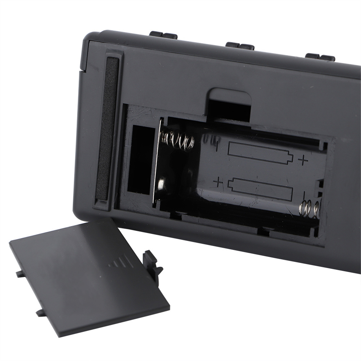 Ein offenes Batteriefach eines schwarzen Geräts, das zwei Batterieschlitze zeigt.