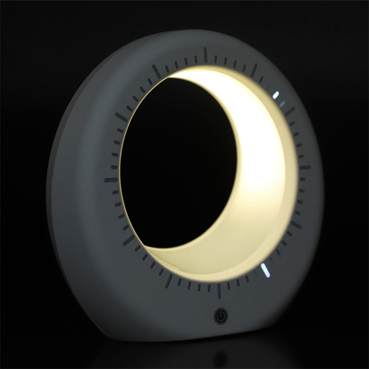 Eine graue ringförmige Lampe mit Licht im Inneren, einem Zifferblatt an den Rändern und einem Ein-/Ausschalter.