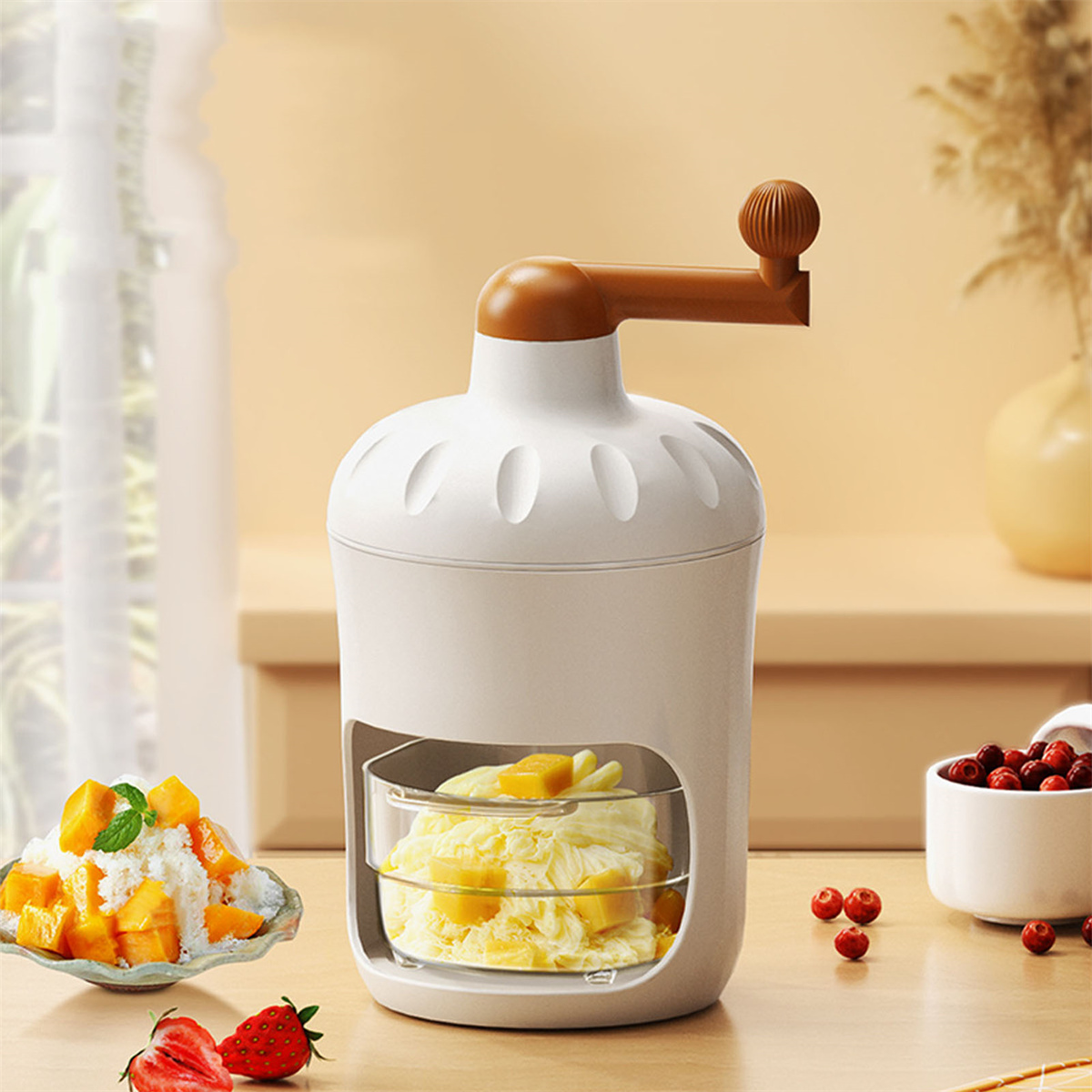 Ein weißer und brauner manueller Eisbereiter mit Mango und Erdbeeren sowie eine Schüssel mit roten Beeren.