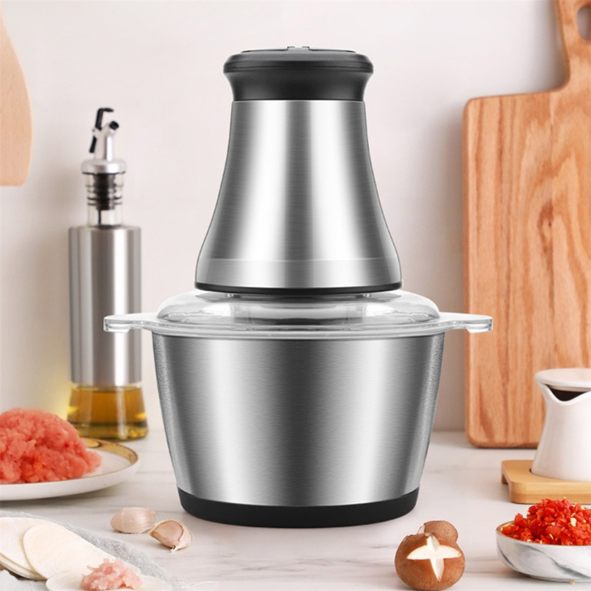 Ein Edelstahl-Foodprocessor mit Zutaten und einem Schneidebrett.