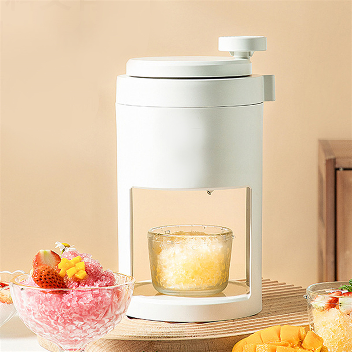 Eine weiße Eisschermaschine mit Fruchtdesserts auf dem Tisch.
