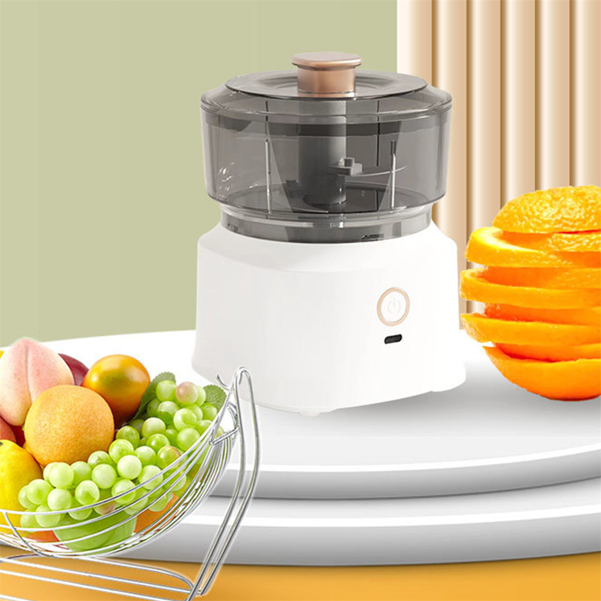 Weißer und grauer Foodprozessor mit Obstkorb und Orangenscheiben auf weißer Oberfläche.