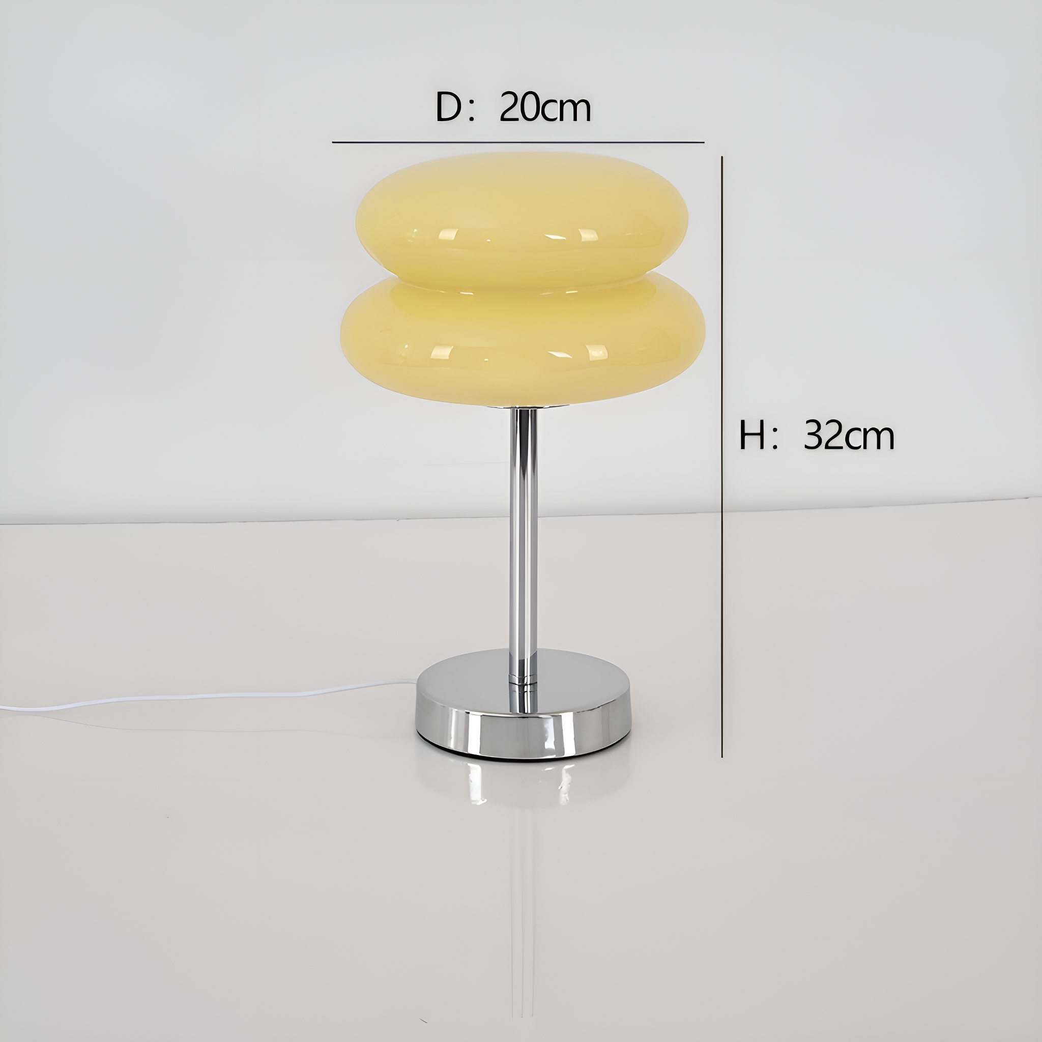 Gelbe Lampe mit Chromfuß und weißem Hintergrund. Abmessungen: D: 20cm, H: 32cm.