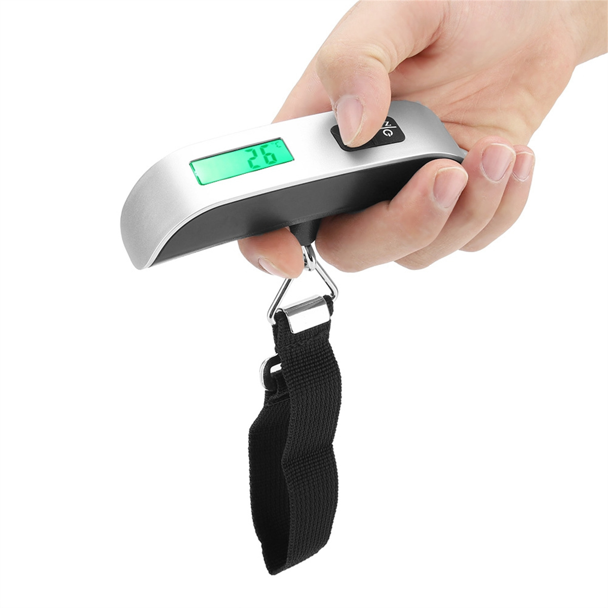 Eine Hand, die eine silberne Gepäckwaage mit digitaler Anzeige hält. Die Anzeige zeigt 26.