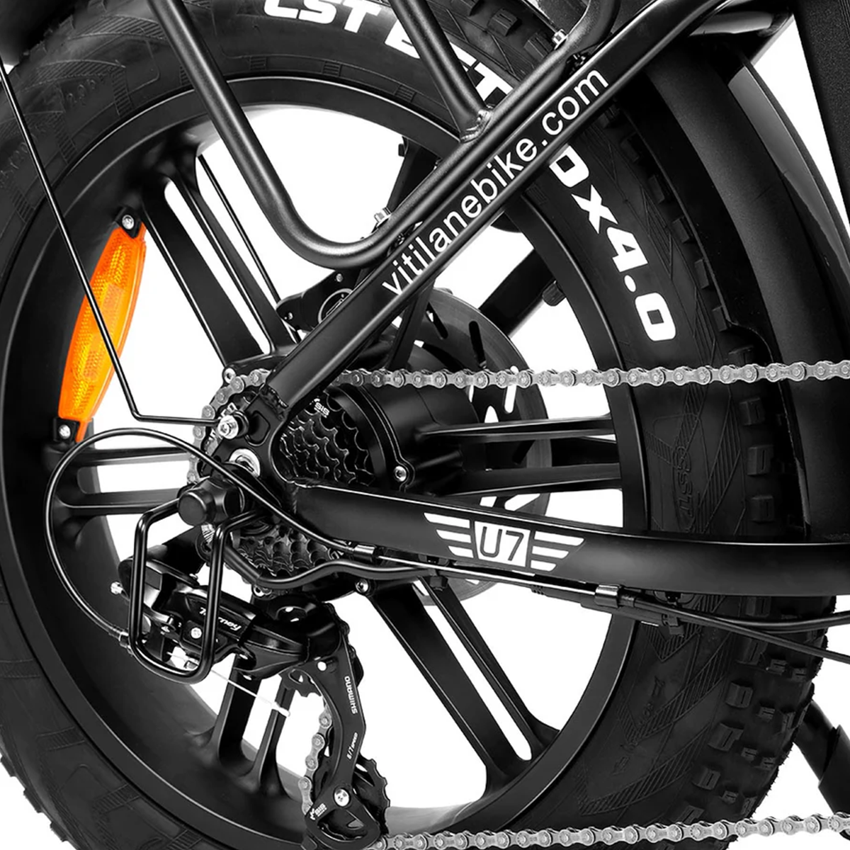 Zbliżenie czarnego koła roweru z napisem na oponie 'vitilanebike.com DX4.0'. Widoczne części metalowe.