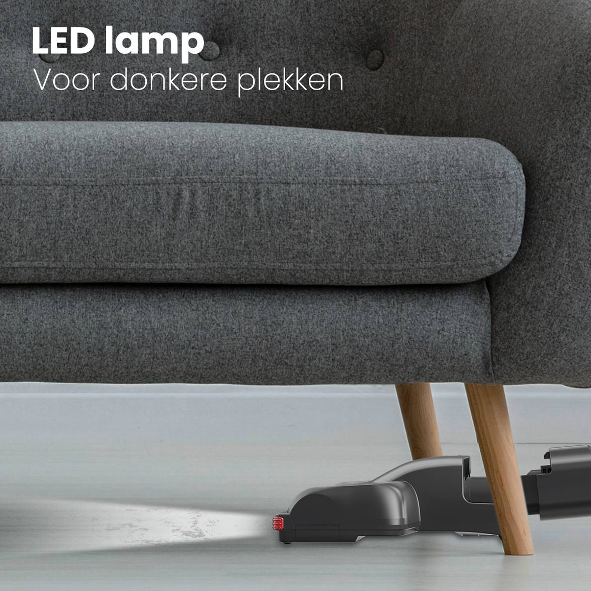 Tête d'aspirateur avec lampe LED et texte, au sol près d'un canapé gris.