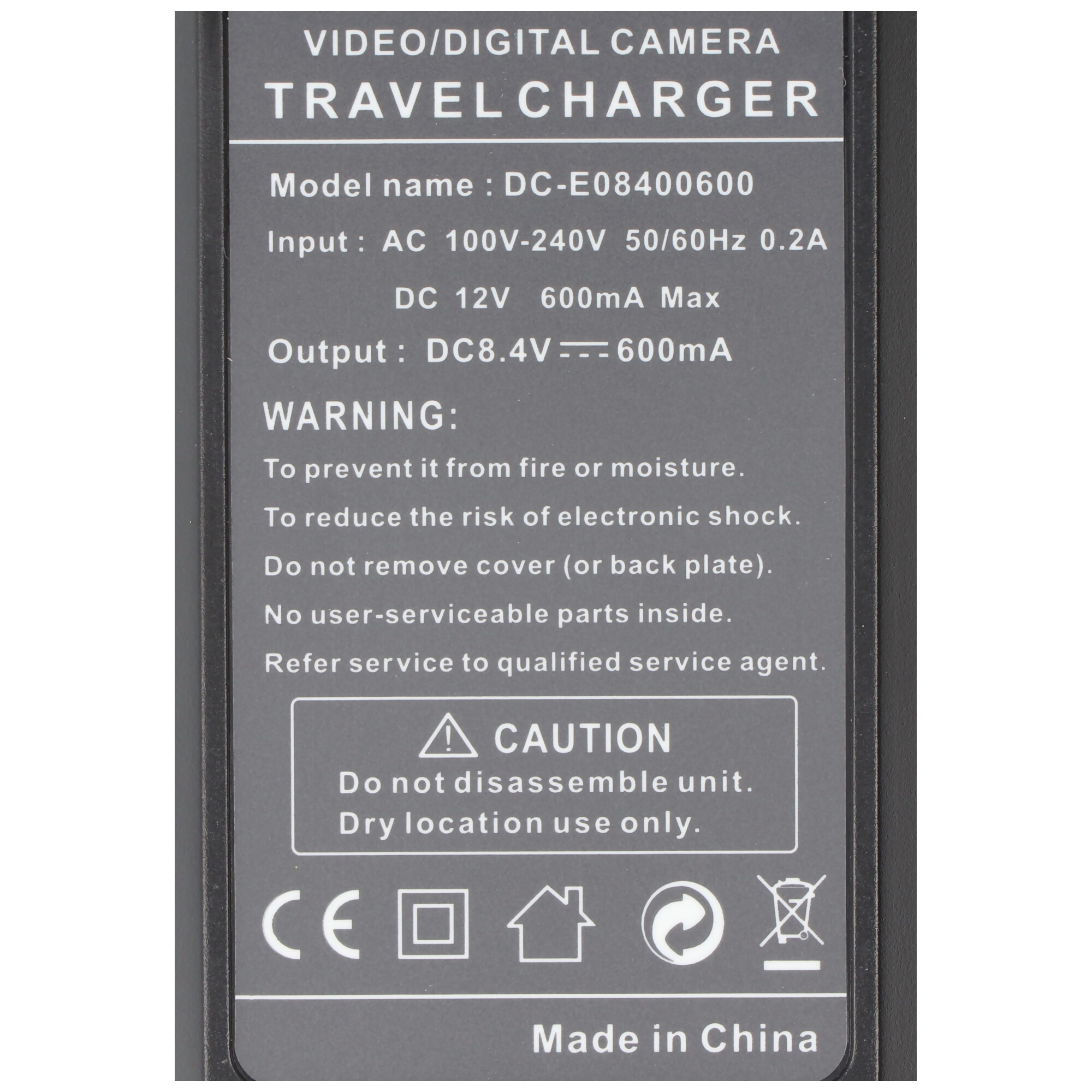 A black travel charger with white text. The text includes input, output, and warning information.