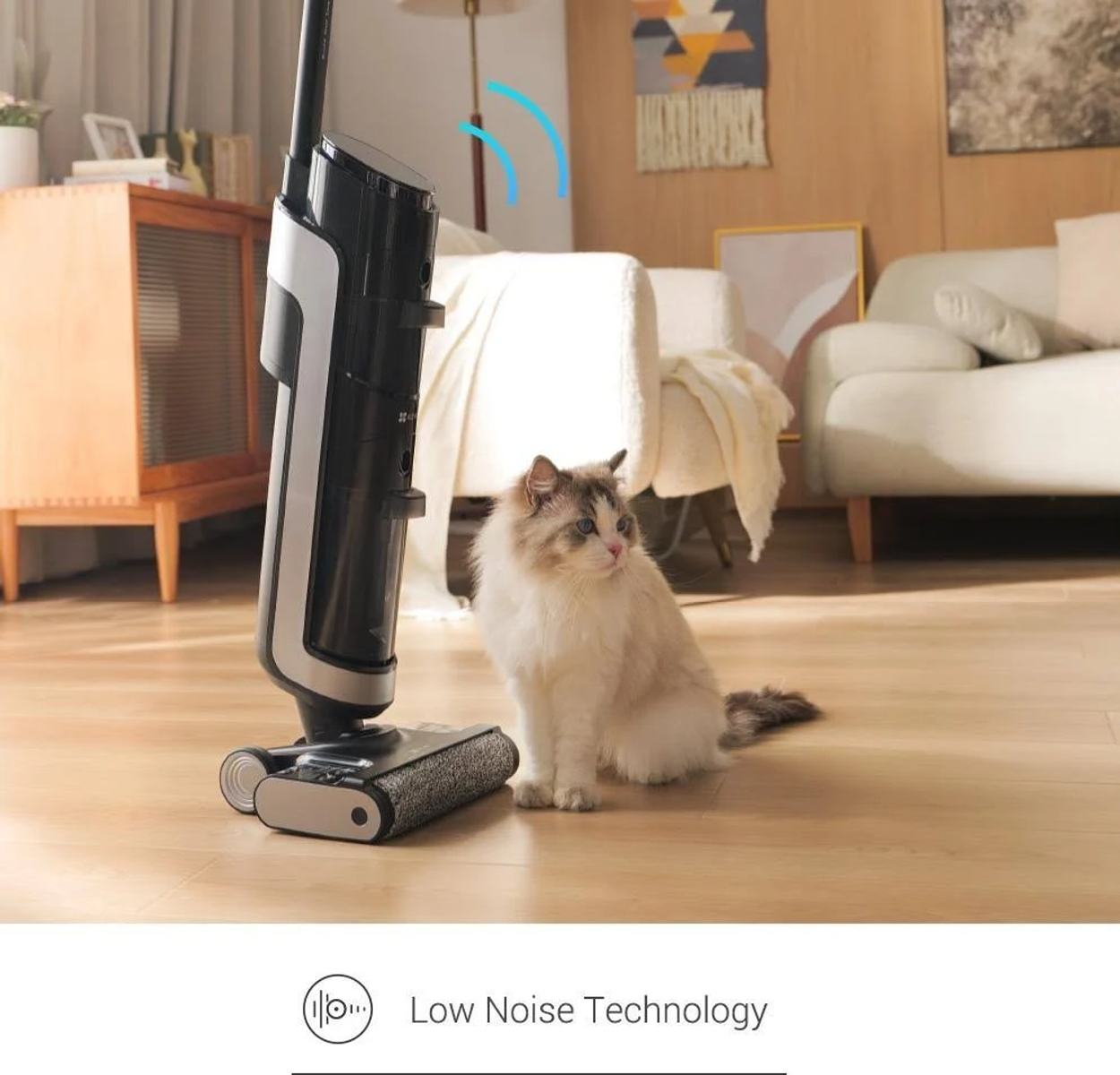 Un mocio bianco e grigio si trova su un pavimento in legno. Un gatto soffice è seduto di fronte al mocio.