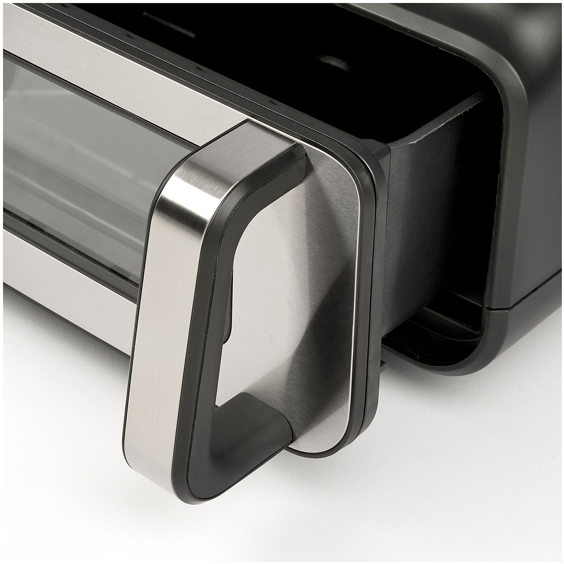 Zbliżenie na czarną i srebrną szufladę frytkownicy beztłuszczowej z uchwytem, na białym tle.