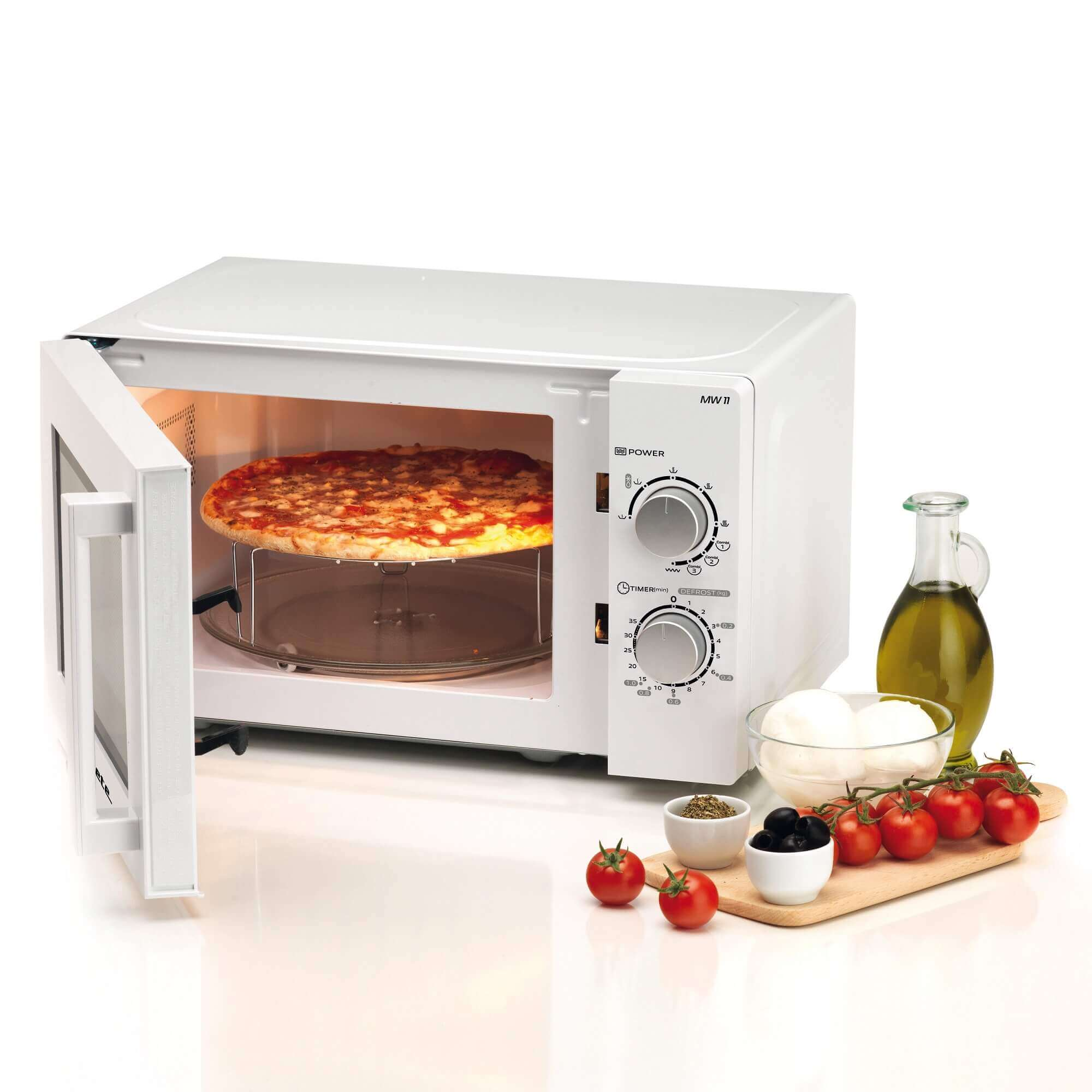 Witte magnetron met pizza erin, tomaten, olie en mozzarella ernaast.