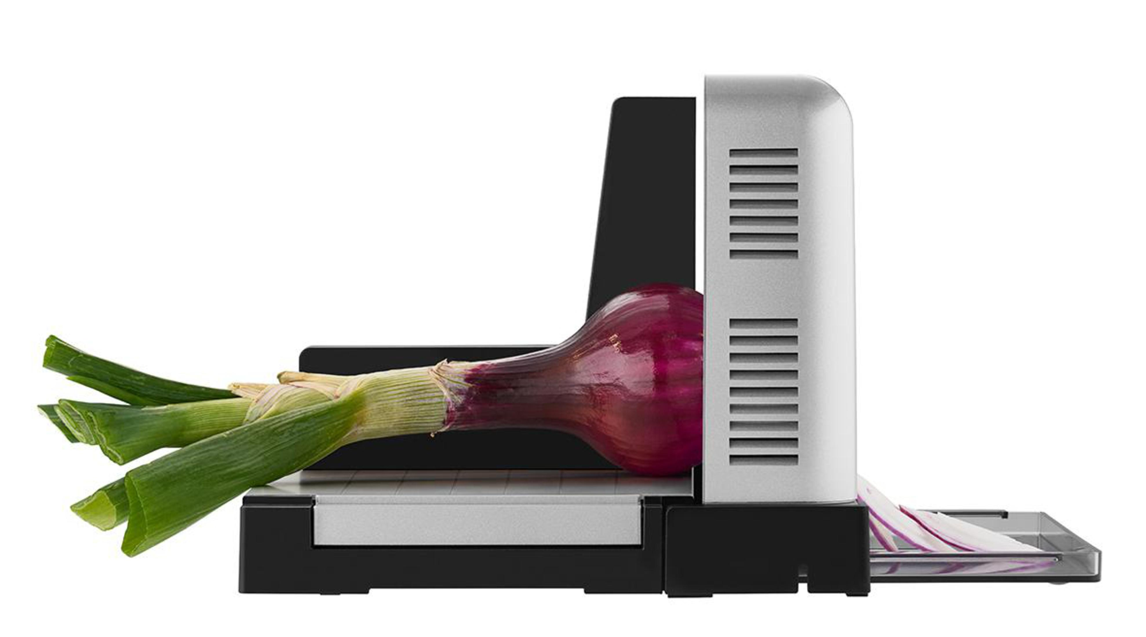 Krajalnica do cebuli z czerwoną cebulą. Krajalnica srebrna i czarna, cebula w miejscu krojenia.