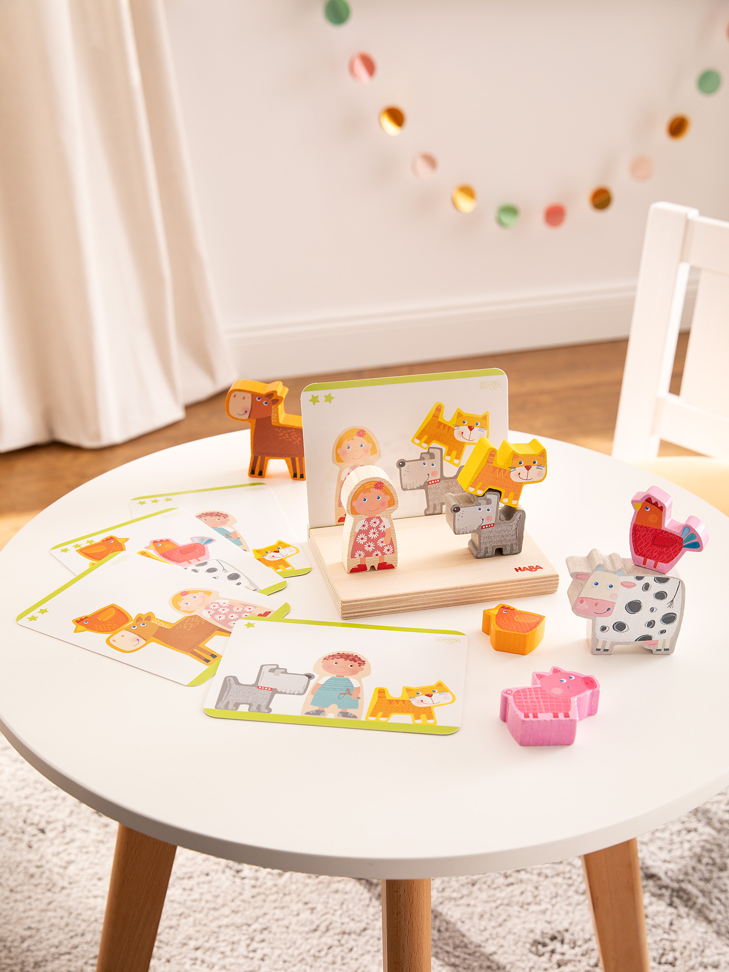Tierpuzzle aus Holz auf weißem Tisch, mit Karten und Holzfigur.
