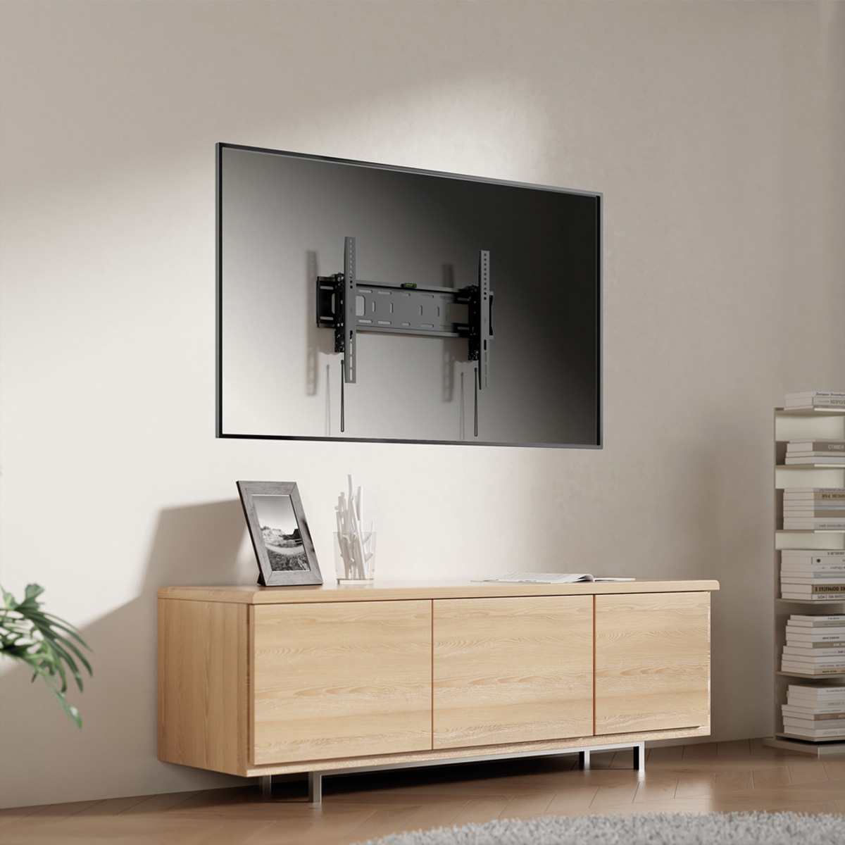 Una TV a parete con un mobile sottostante, una cornice e decorazioni.