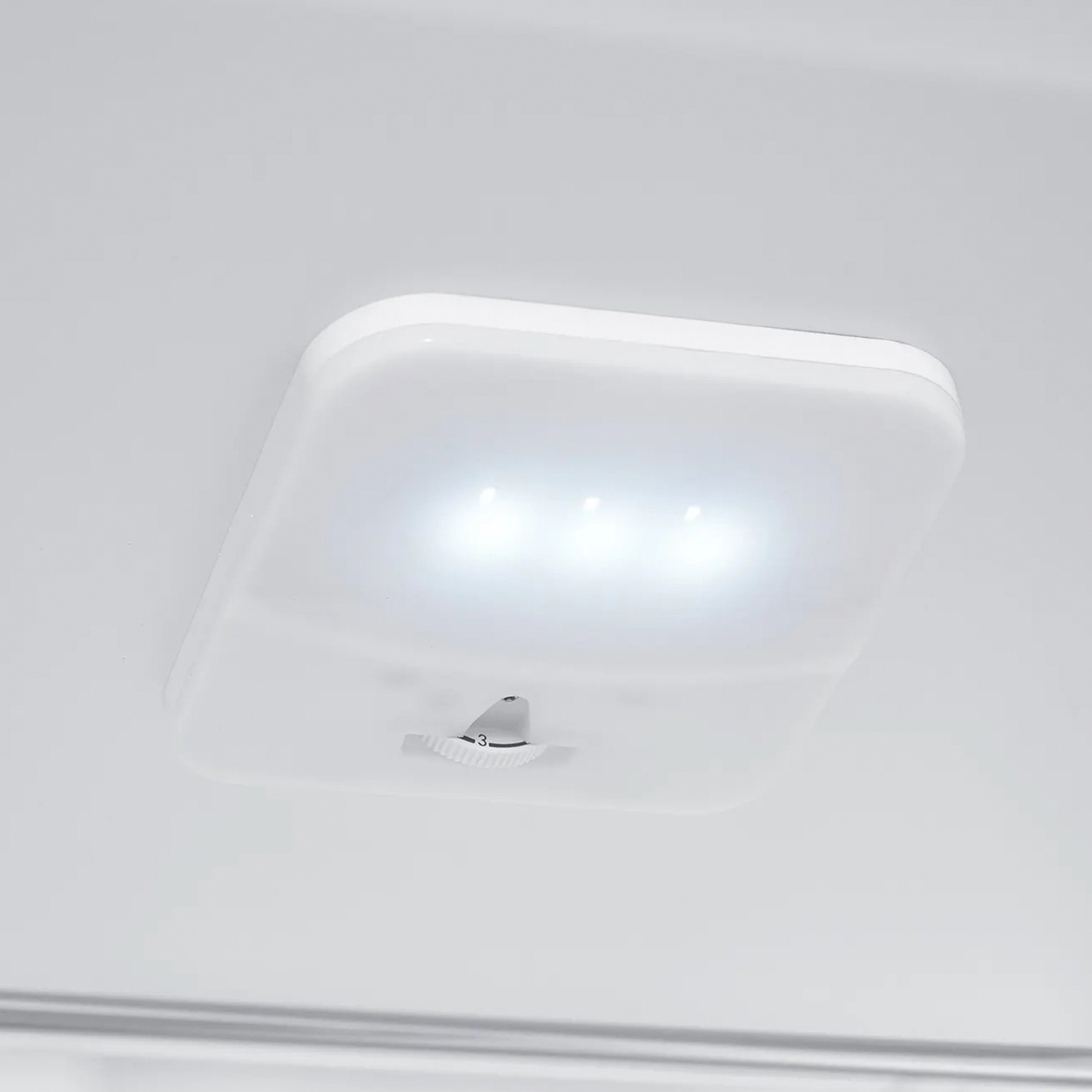 Luz interior de refrigerador blanco con tres bombillas y un interruptor de atenuación.