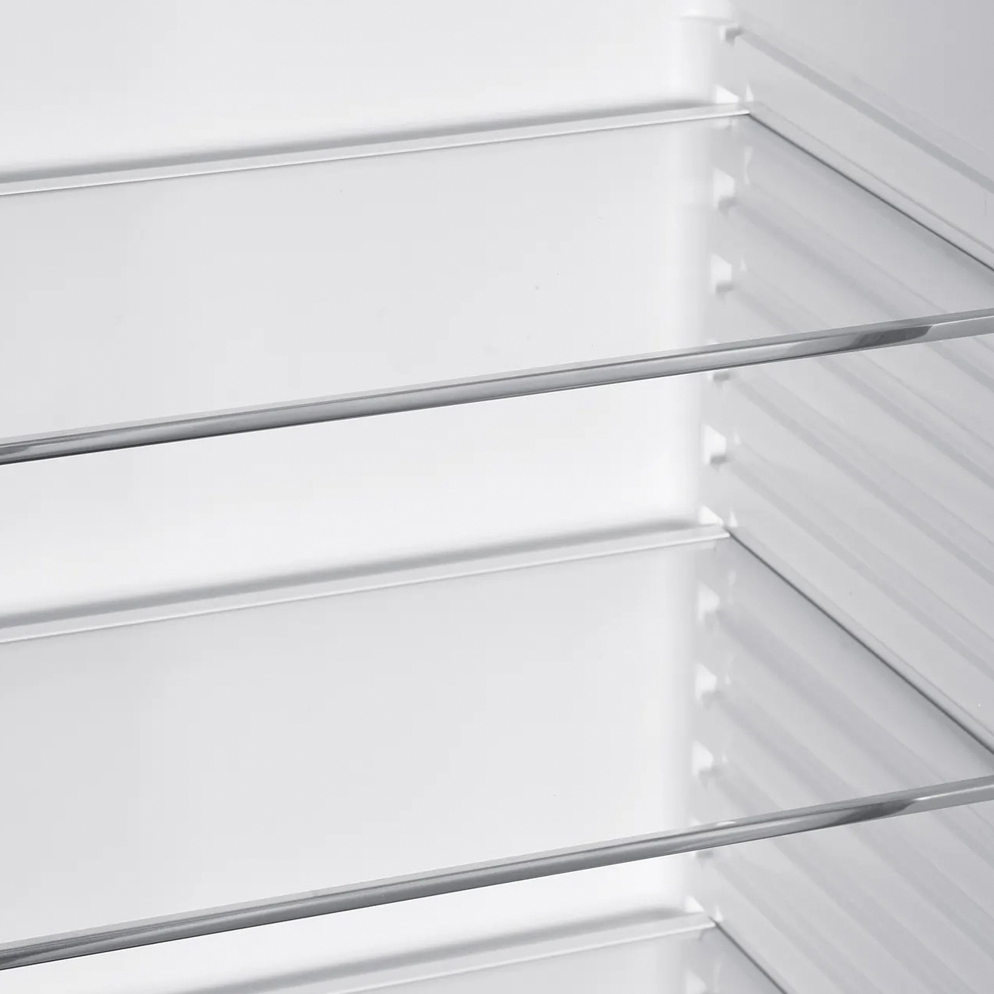 Vista interior de un refrigerador con estantes de vidrio.