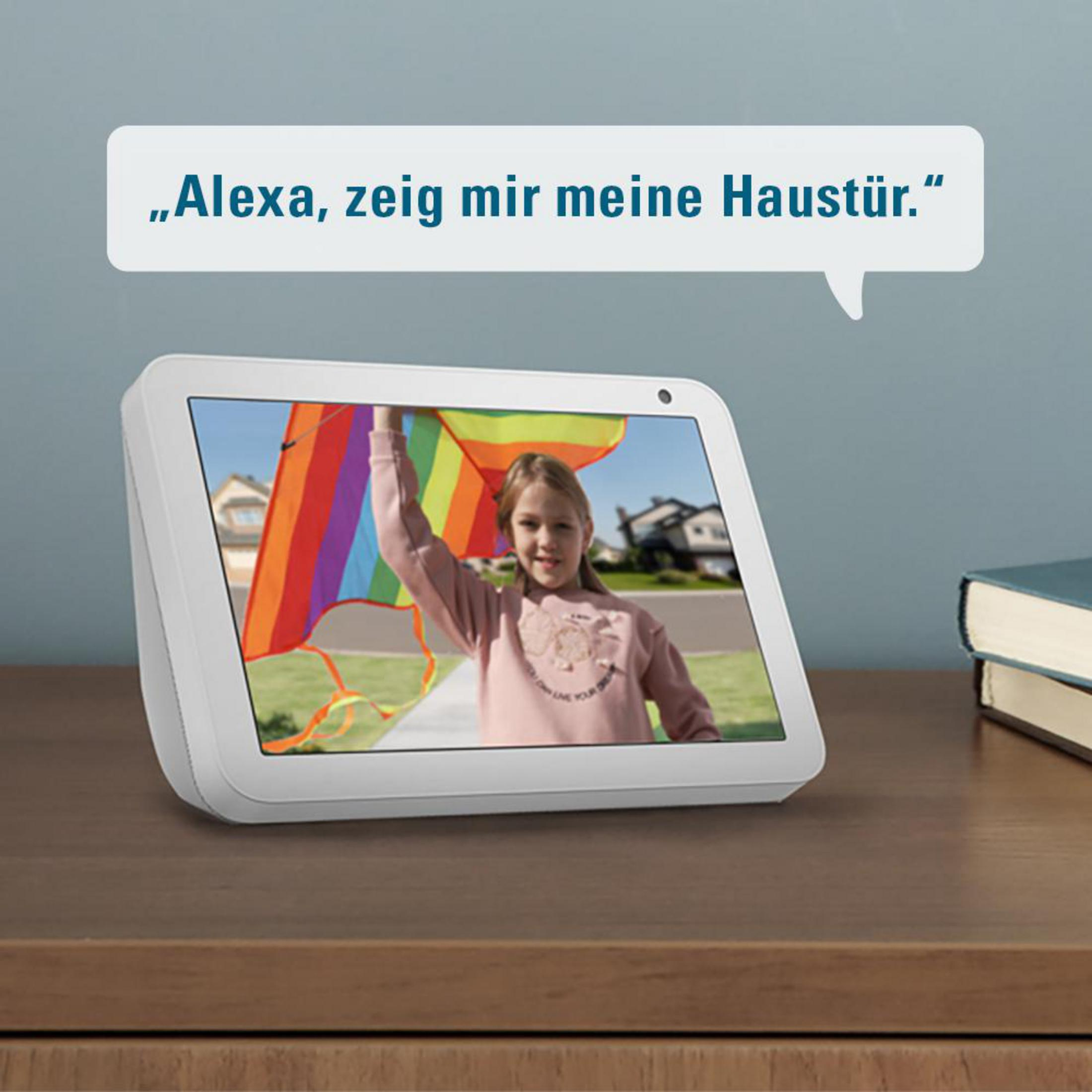 Inteligentny wyświetlacz pokazujący dziewczynkę trzymającą latawiec. Tekst u góry brzmi 'Alexa, pokaż mi moje drzwi wejściowe'.