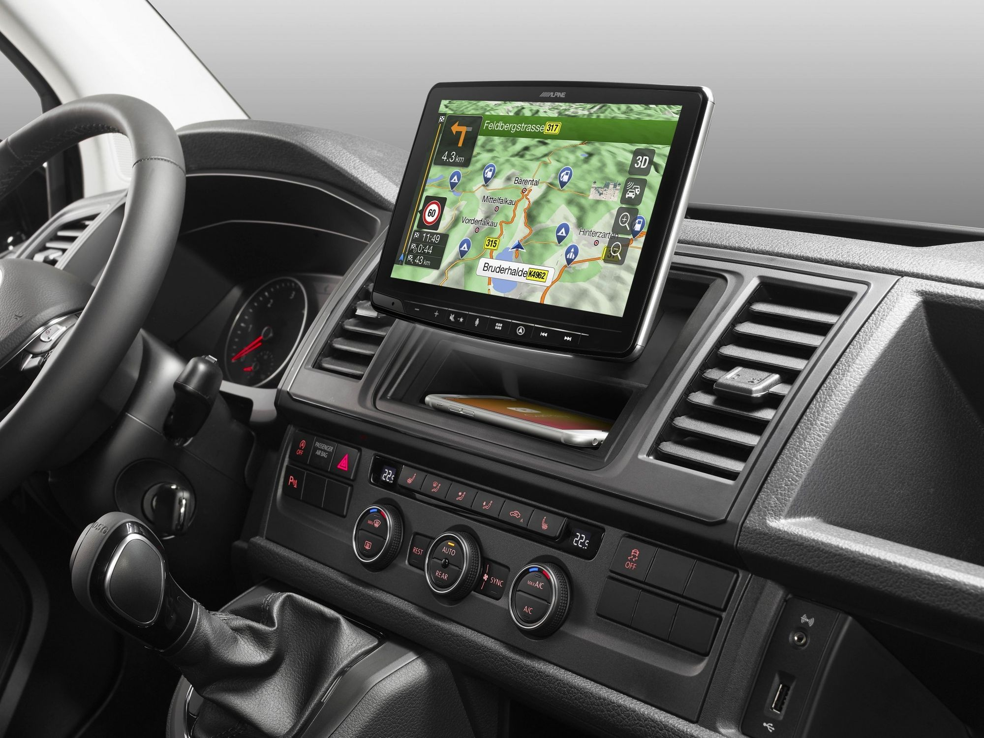 Armaturenbrett eines Autos mit GPS-Bildschirm, der eine Karte anzeigt, und einem Telefon im Ablagefach.