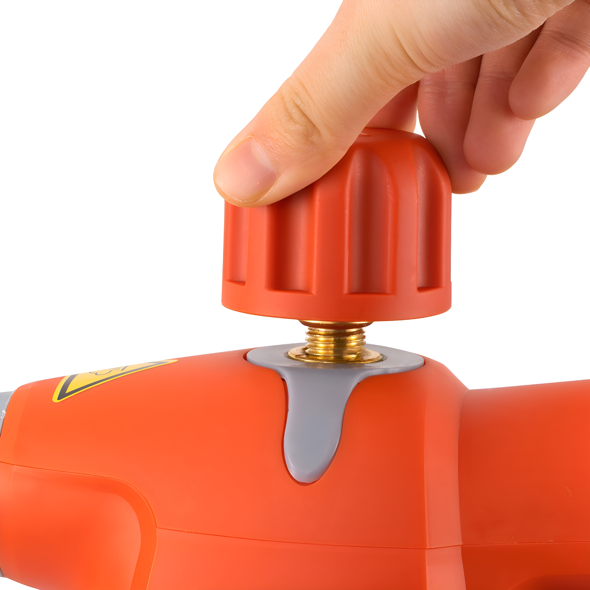Hand dreht roten Knopf an orangefarbenem Gerät, mit goldenem Schraubendetail.