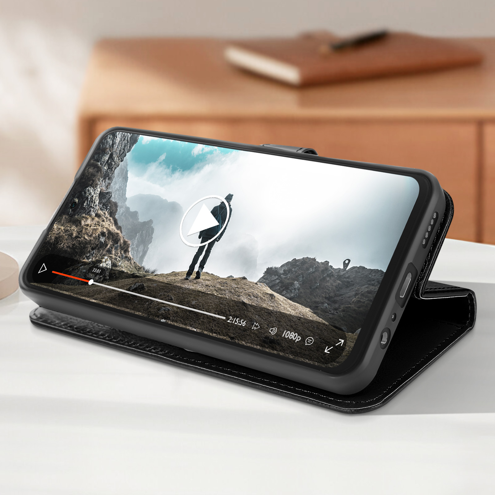 Telefono in custodia nera, mostra video con persona su una montagna.