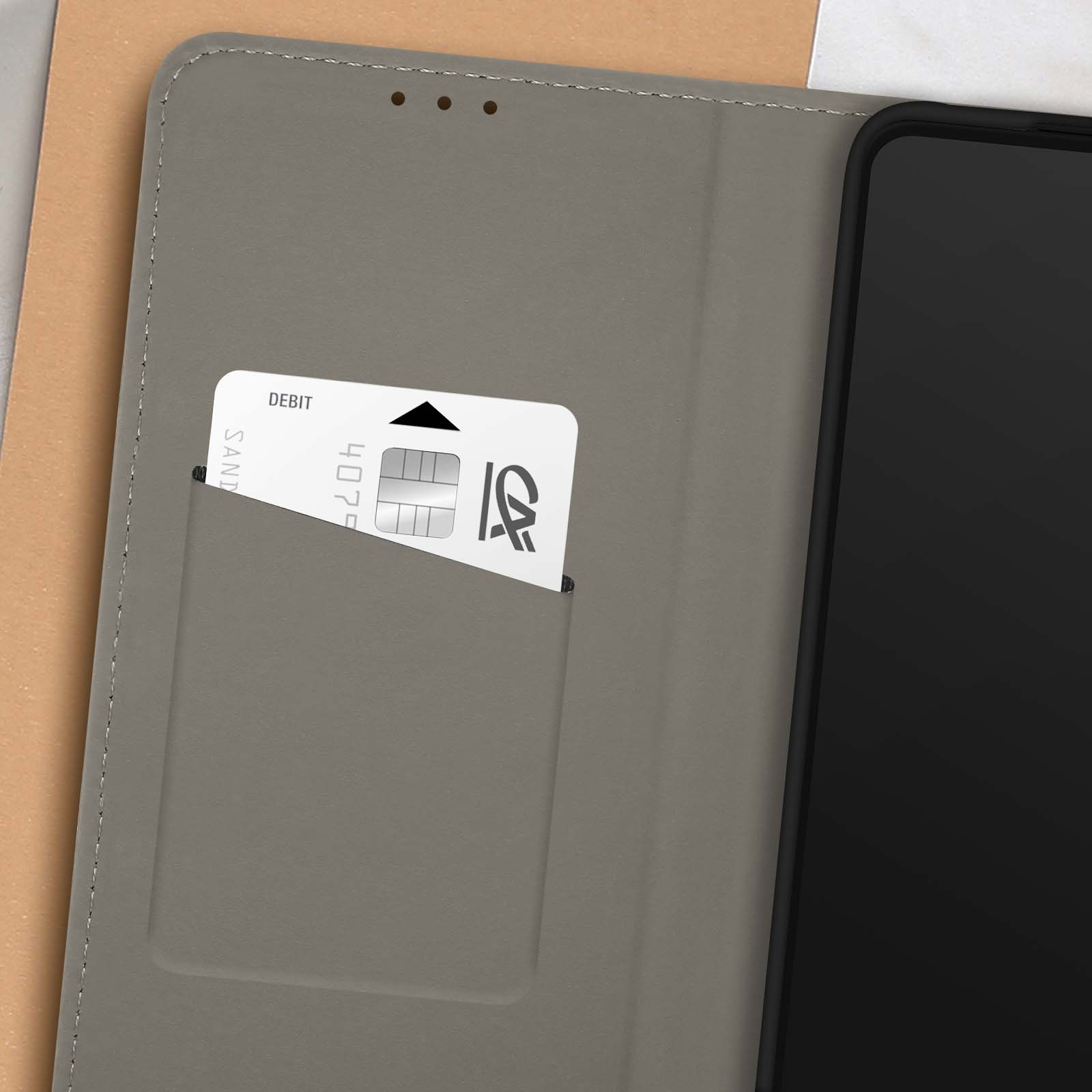 Coque de téléphone grise avec une carte à l'intérieur. La carte indique 'DEBIT' et porte un logo.