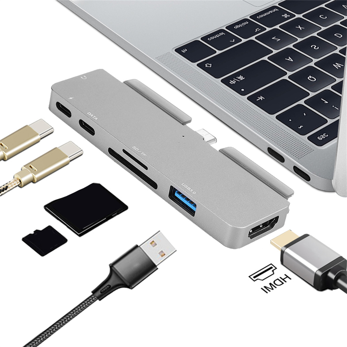 Ein grauer USB-Hub mit verschiedenen Anschlüssen, Kabeln und einem Laptop. Kabel umfassen USB und HDMI.