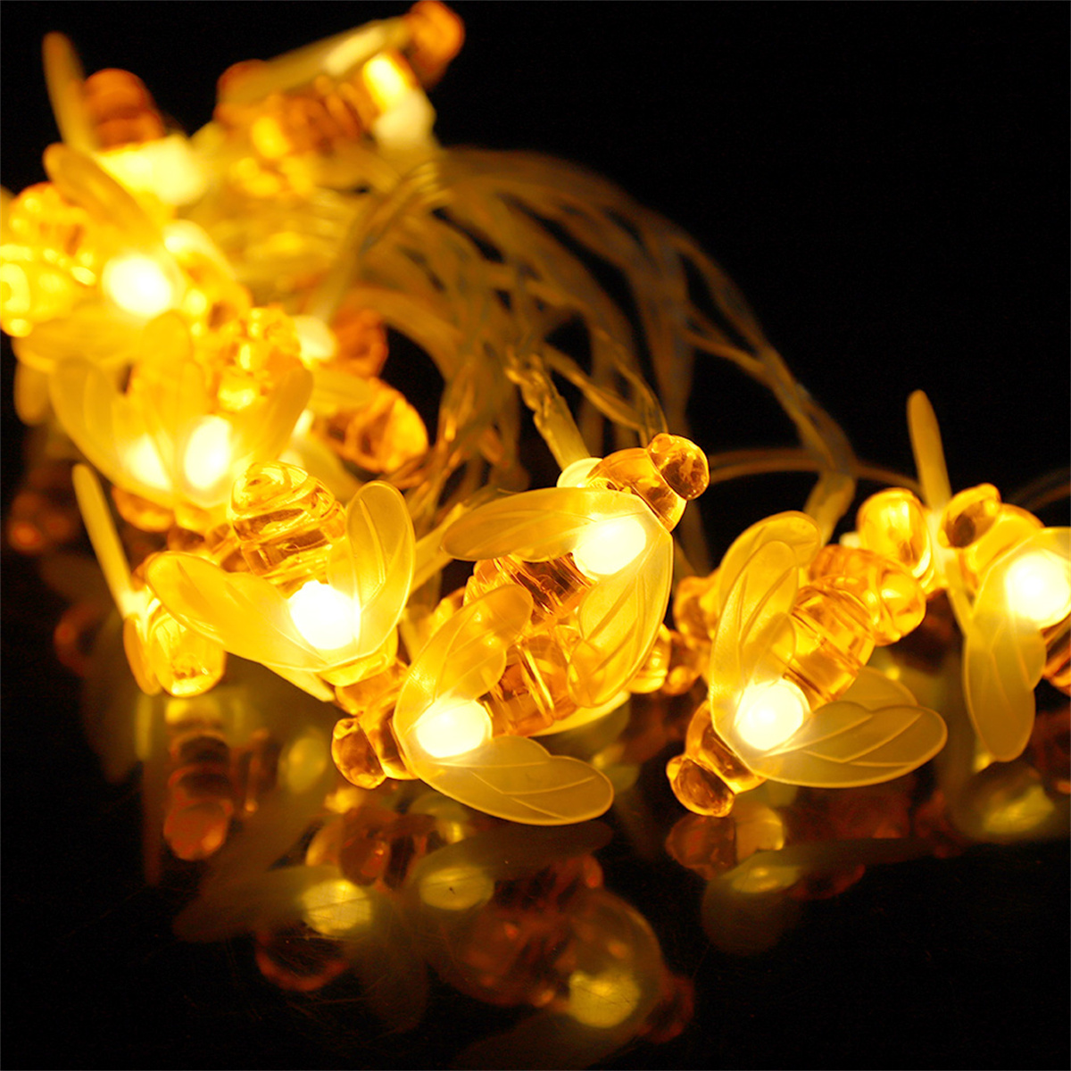 Gelbe bienenförmige Lichter auf schwarzem Hintergrund. Die Lichter leuchten.