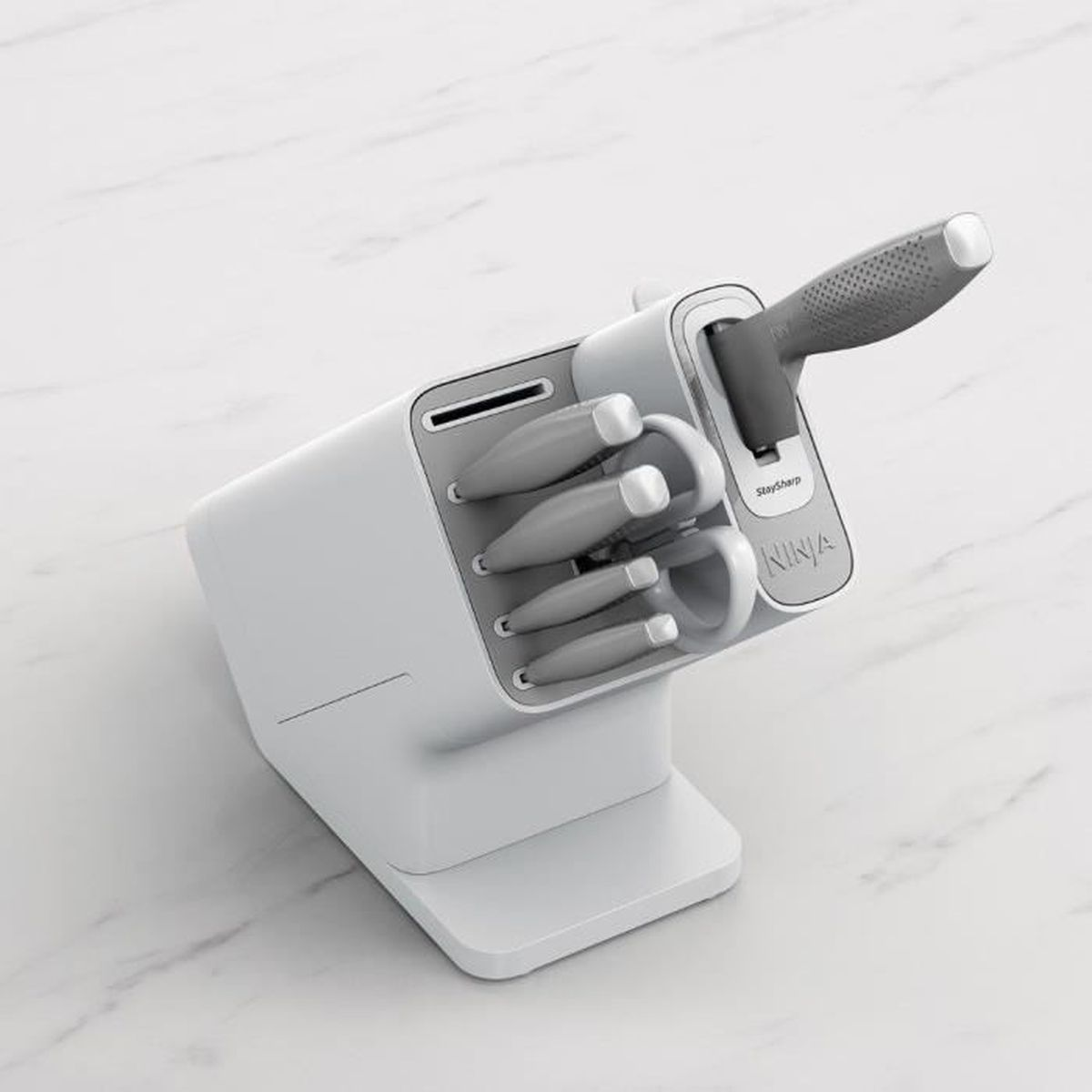 Ein weißer Messerblock mit grauen Messern. Die Messer sind in verschiedenen Größen.