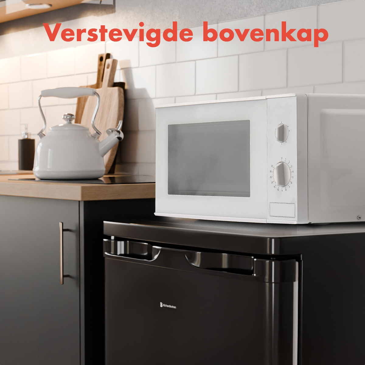 Cuisine avec micro-ondes blanc sur réfrigérateur noir; mur en carrelage blanc.