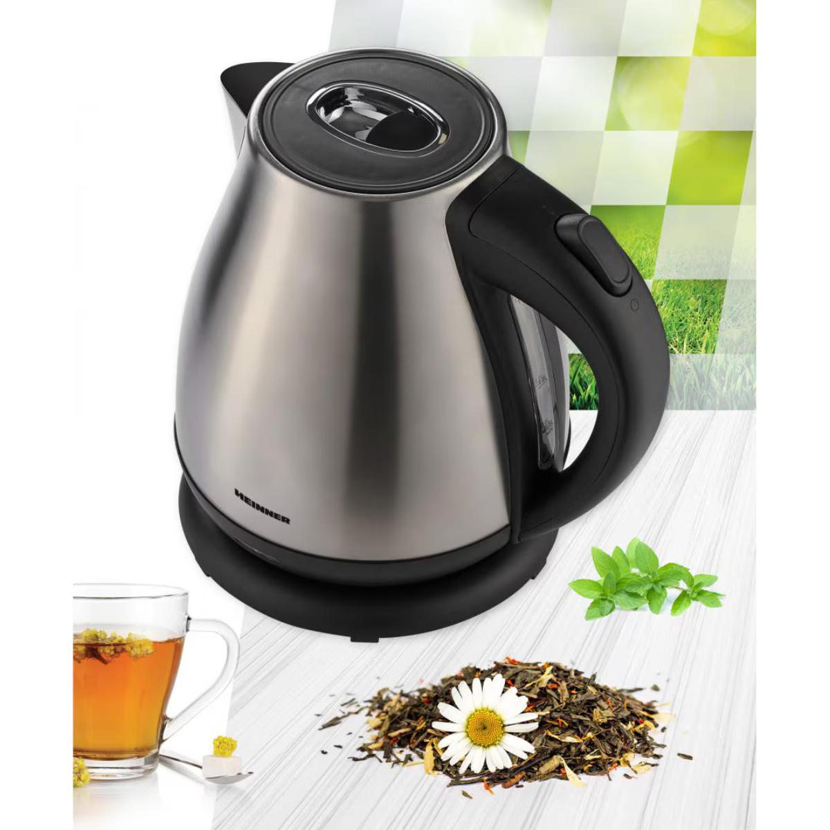 A stainless steel electric kettle, with tea and ingredients on the table.