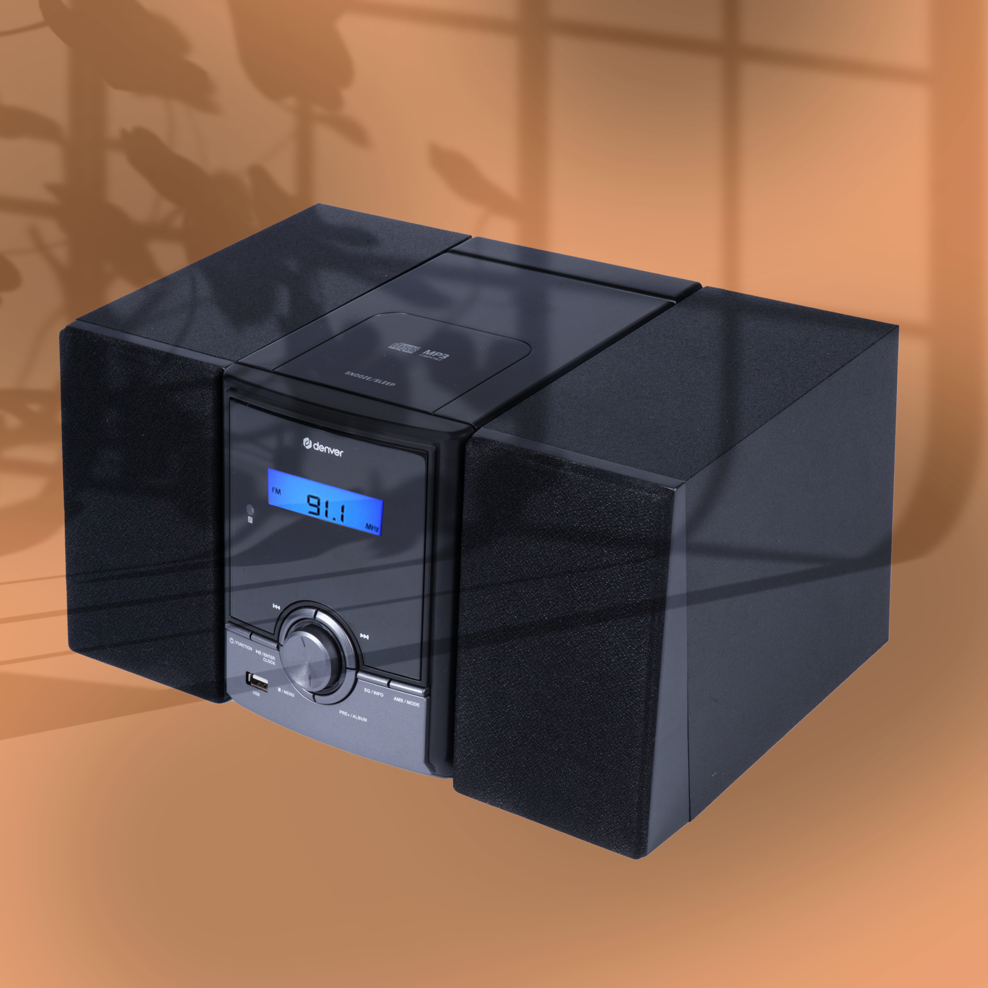 Czarny system stereo z niebieskim wyświetlaczem na pomarańczowym tle.