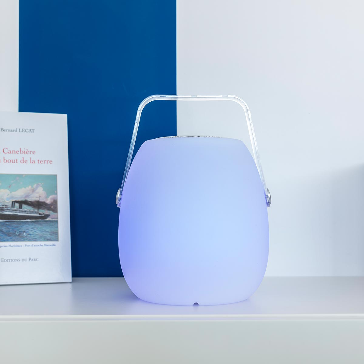 Una lampada arrotondata e luminosa con una maniglia. Emette luce blu e viola.