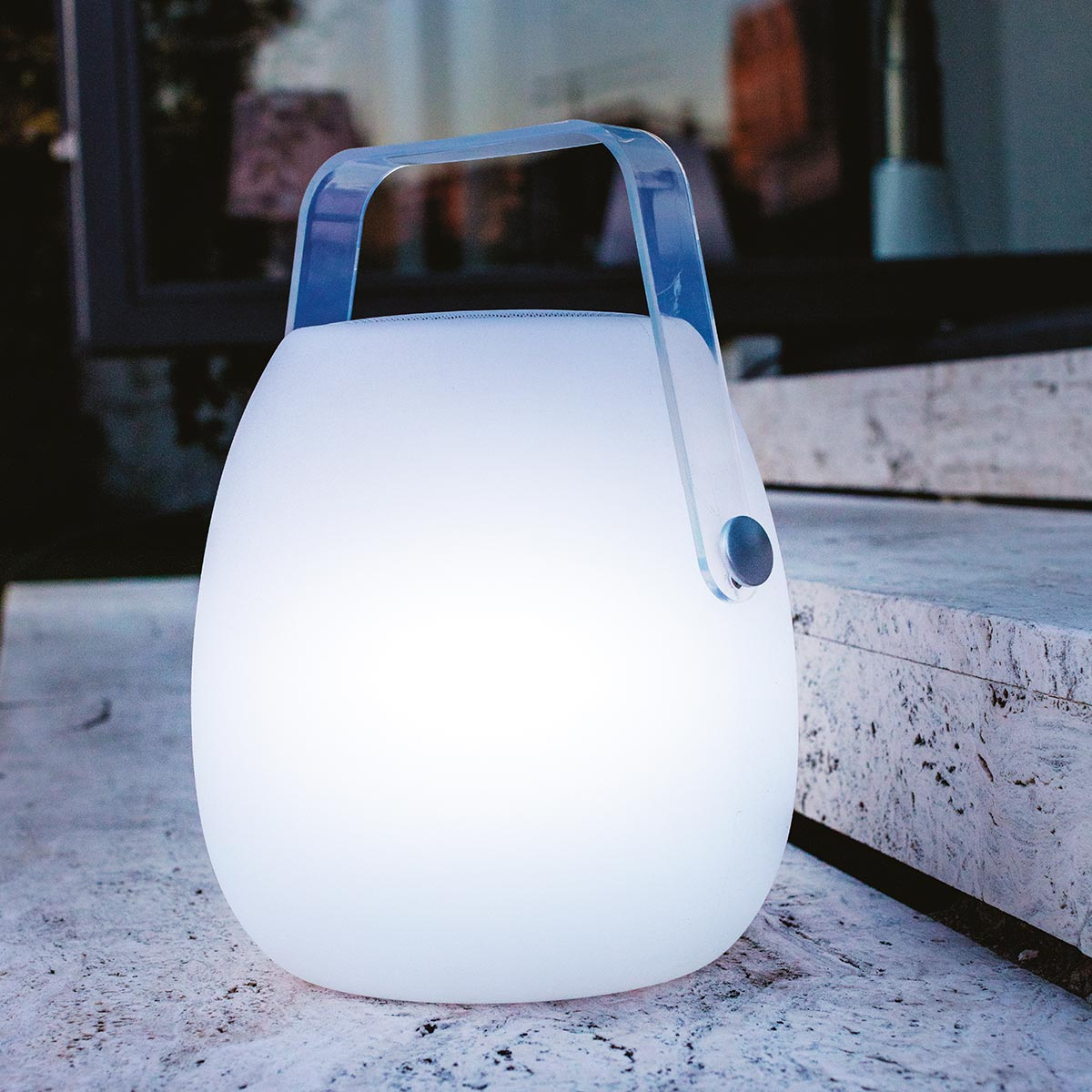 Lampada da esterno bianca con manico. La lampada si illumina di luce.