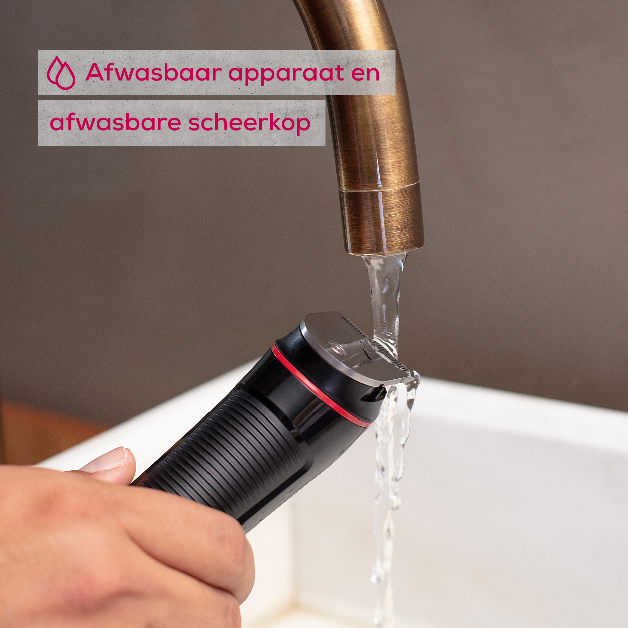 Hand die een zwarte en rode trimmer onder een waterstraal houdt.