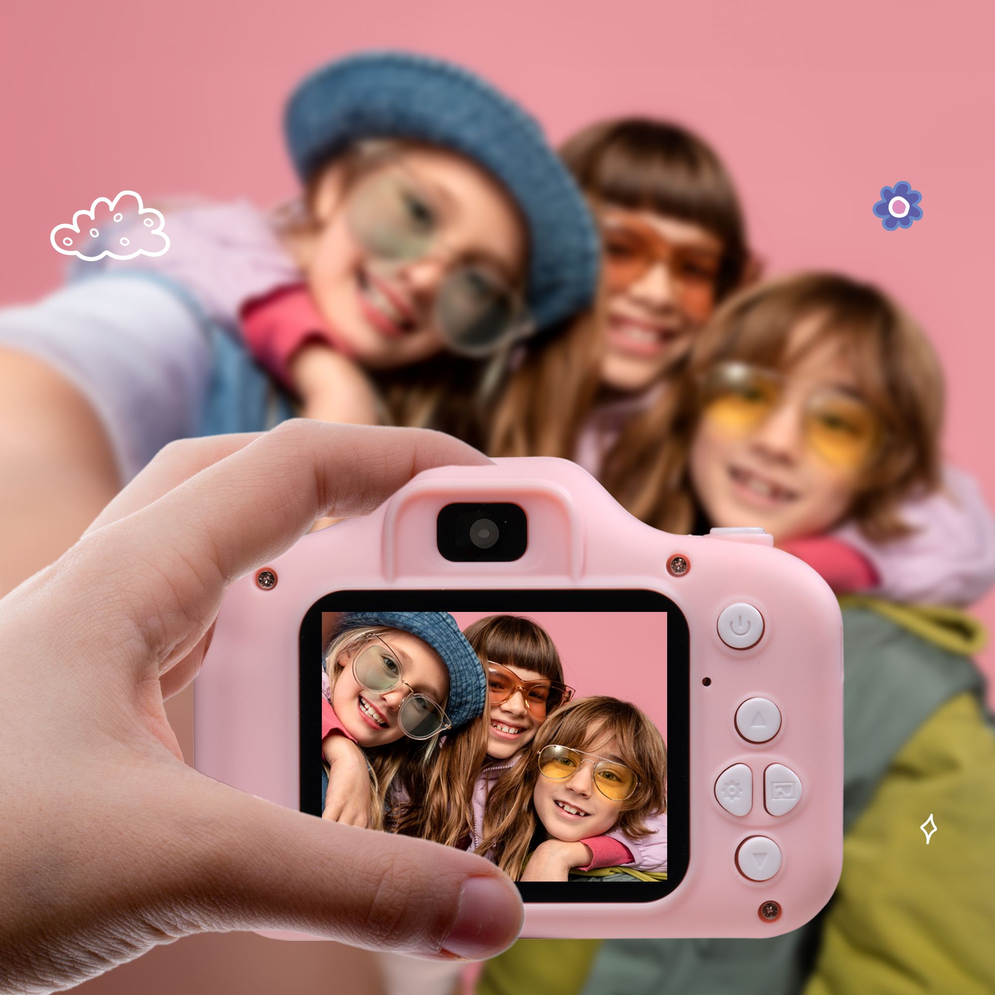 A child holding a pink camera taking a photo of three children smiling. Pink background.