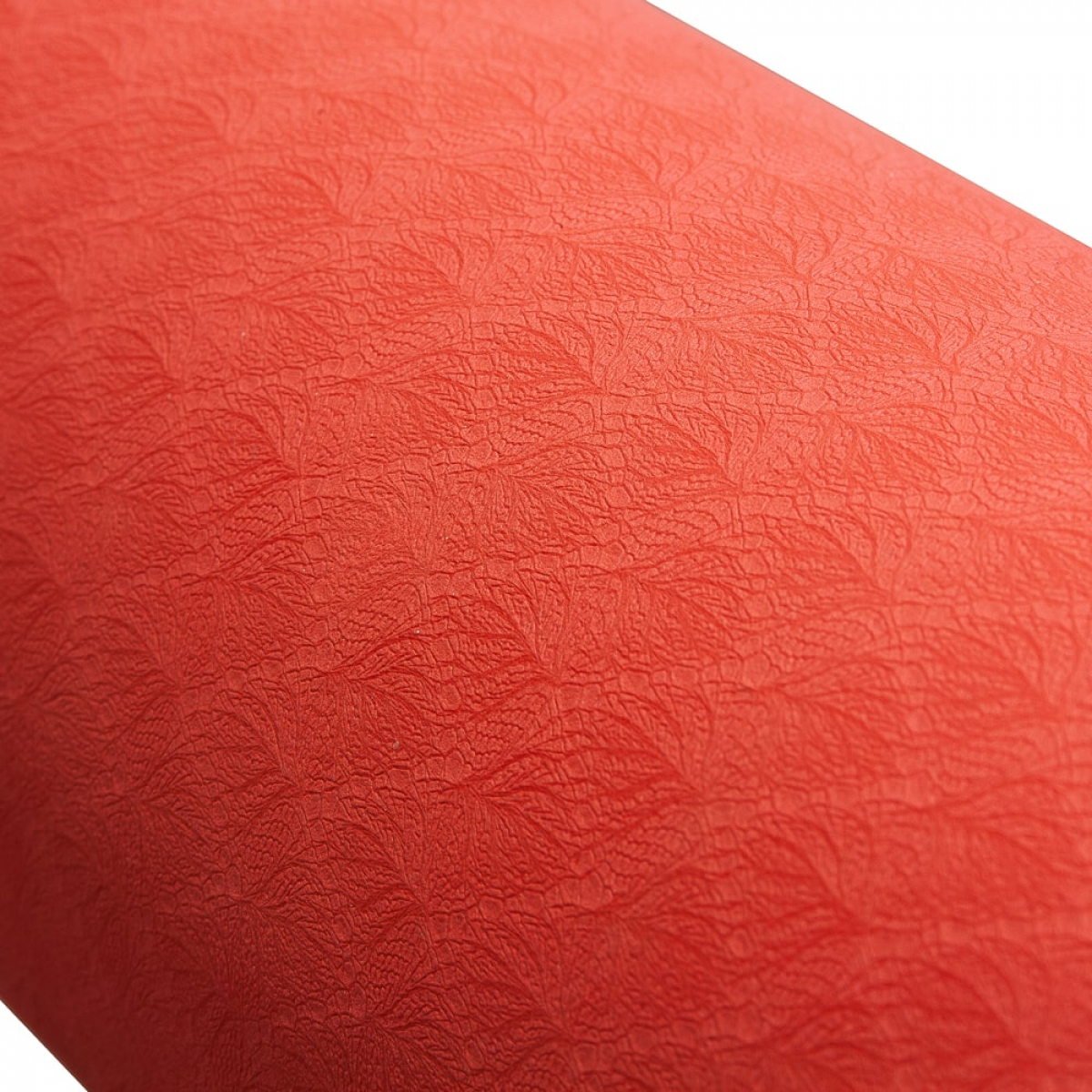 Close-up of textured red surface, with a pattern resembling veins or cracks. White background.