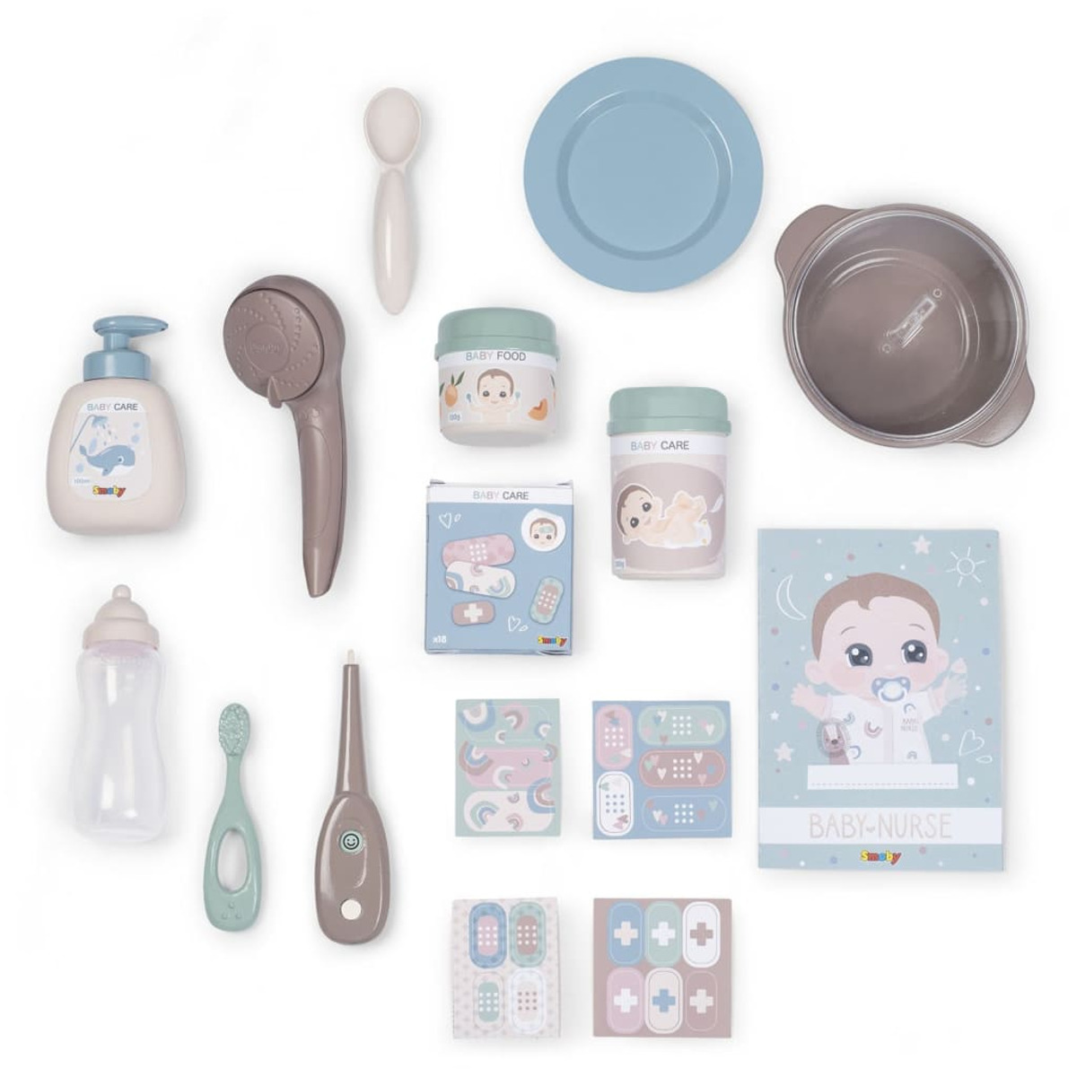 Babypflege-Set: Flaschen, Nahrung, Medikamente, Zahnbürste und Spielzeug, auf Weiß angeordnet.