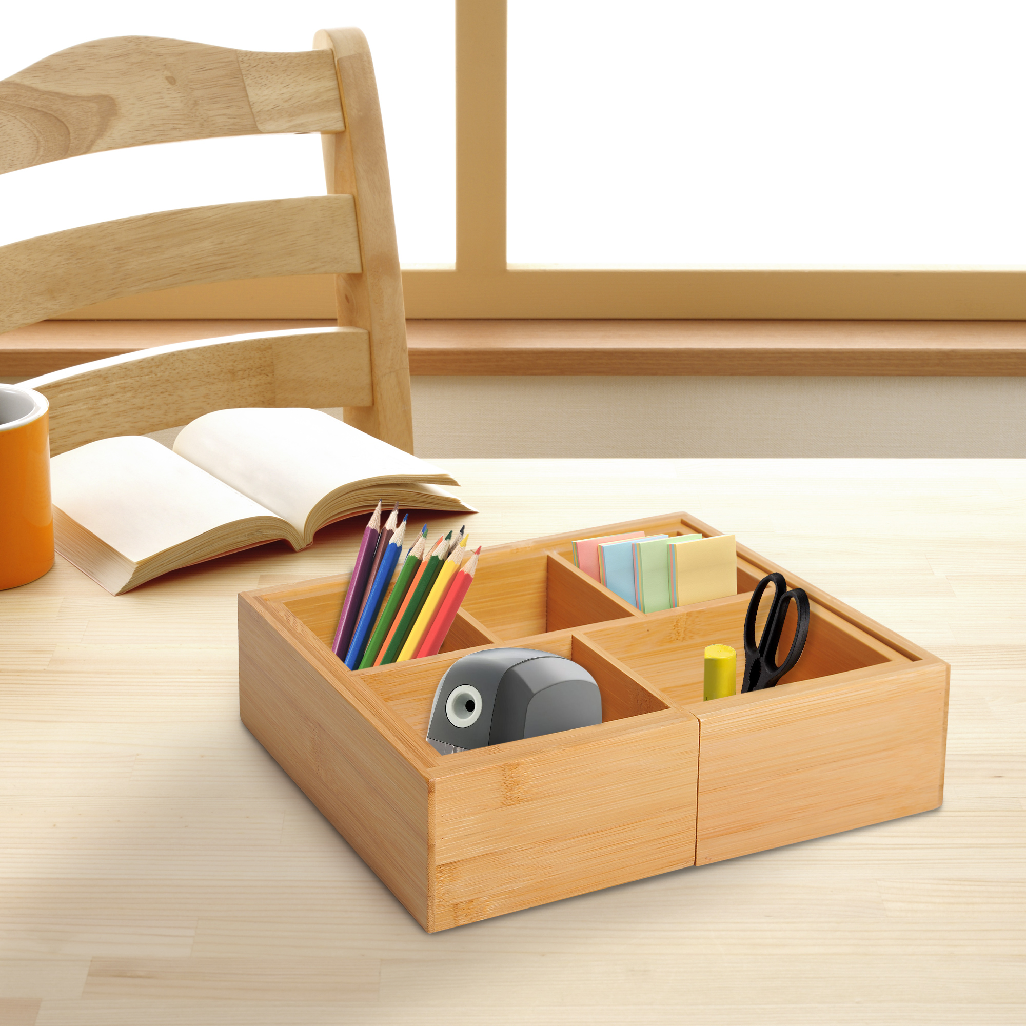 Organizador de escritorio de madera con lápices, notas adhesivas, tijeras, sacapuntas y libro.