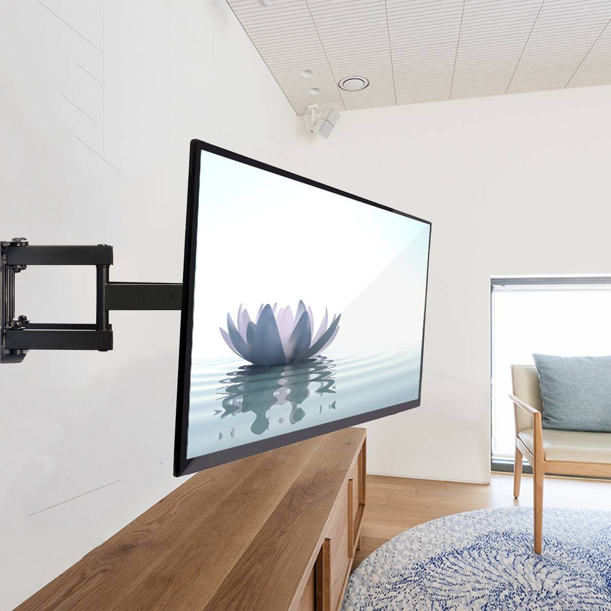 A TV mounted on a wall. The TV shows a flower in water, a wooden cabinet is below.