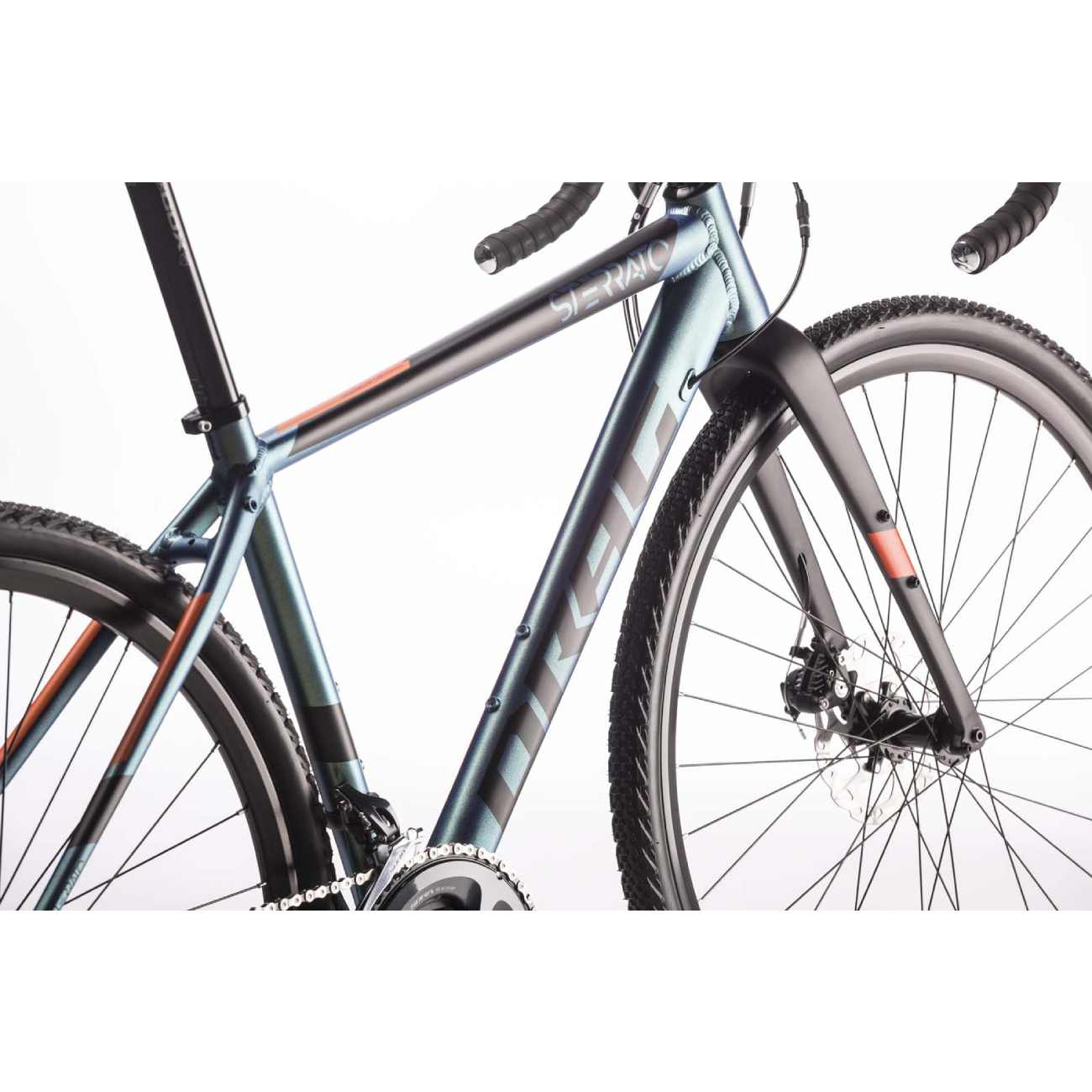 Ein graues und orangefarbenes Fahrrad steht vor weißem Hintergrund. Das Fahrrad hat schwarze Reifen und Lenker.