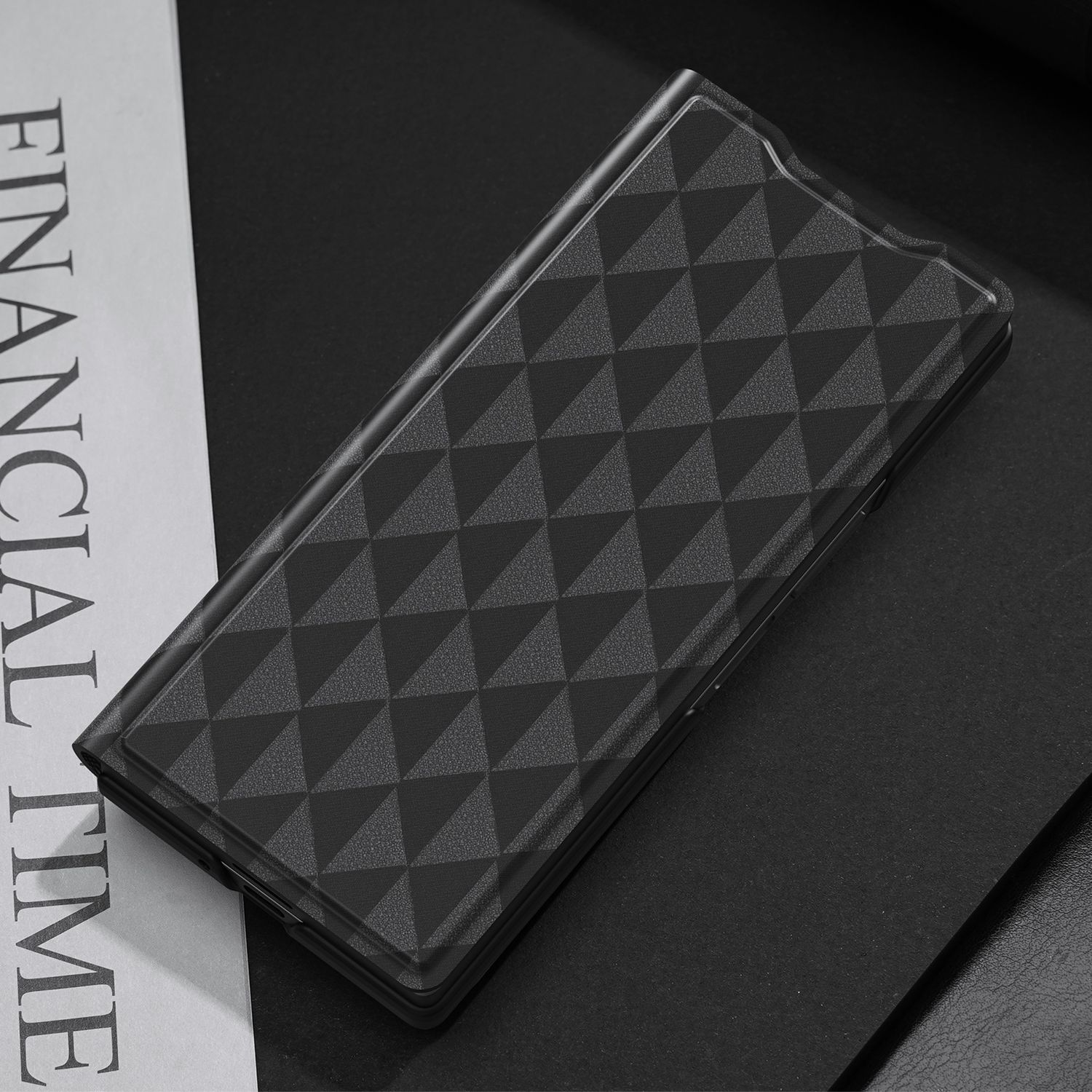 Una funda de teléfono negra estampada sobre una superficie negra con las palabras 'FINANCIAL TIME'.