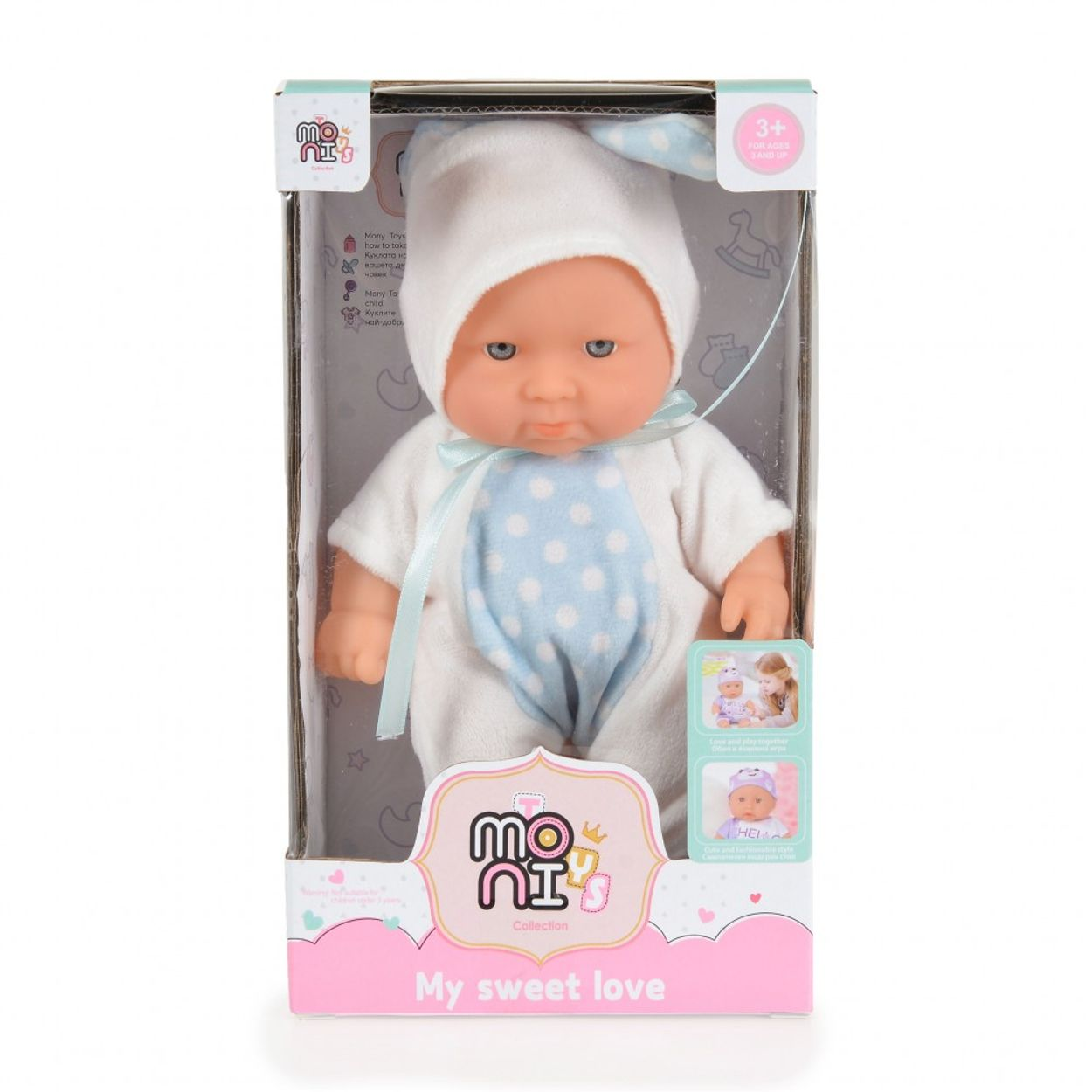 Babypuppe in einer Box, trägt einen weißen Strampler und einen blauen Hut.