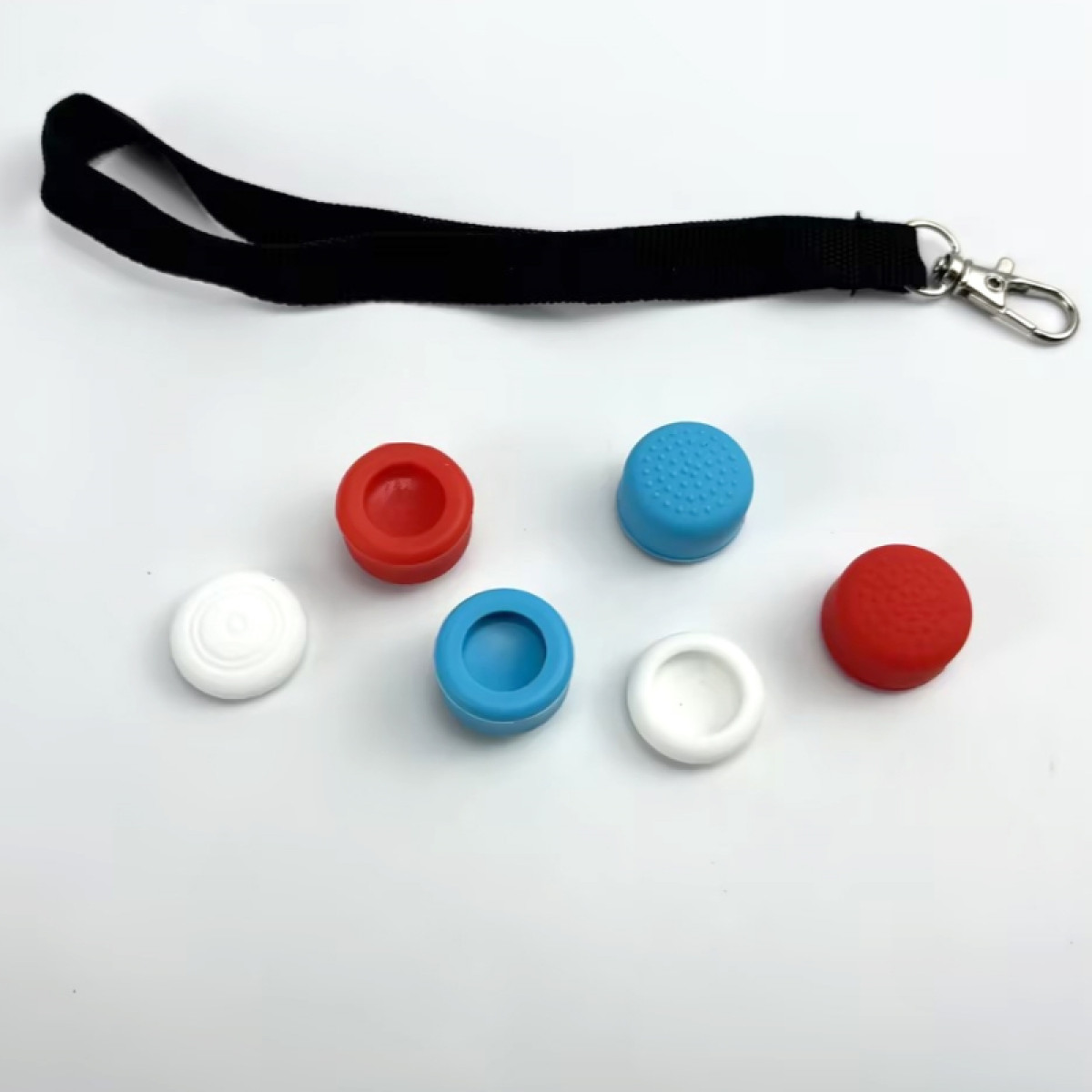 Sechs Controller-Daumengriffe. Weiß, rot und blau in verschiedenen Formen. Auf weißem Hintergrund.