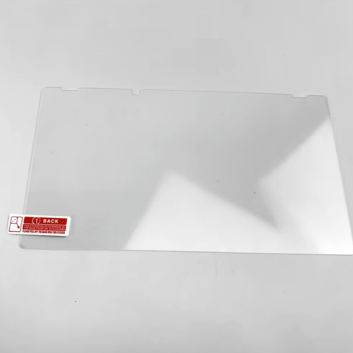 Ein klarer, rechteckiger Bildschirmschutz mit Abziehlasche auf weißer Oberfläche.