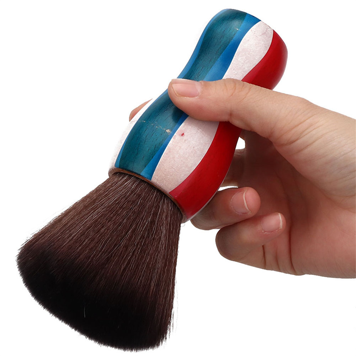 Hand hält einen Barbierpinsel mit rot, weiß und blauem Griff und einem braunen Bürstenkopf.