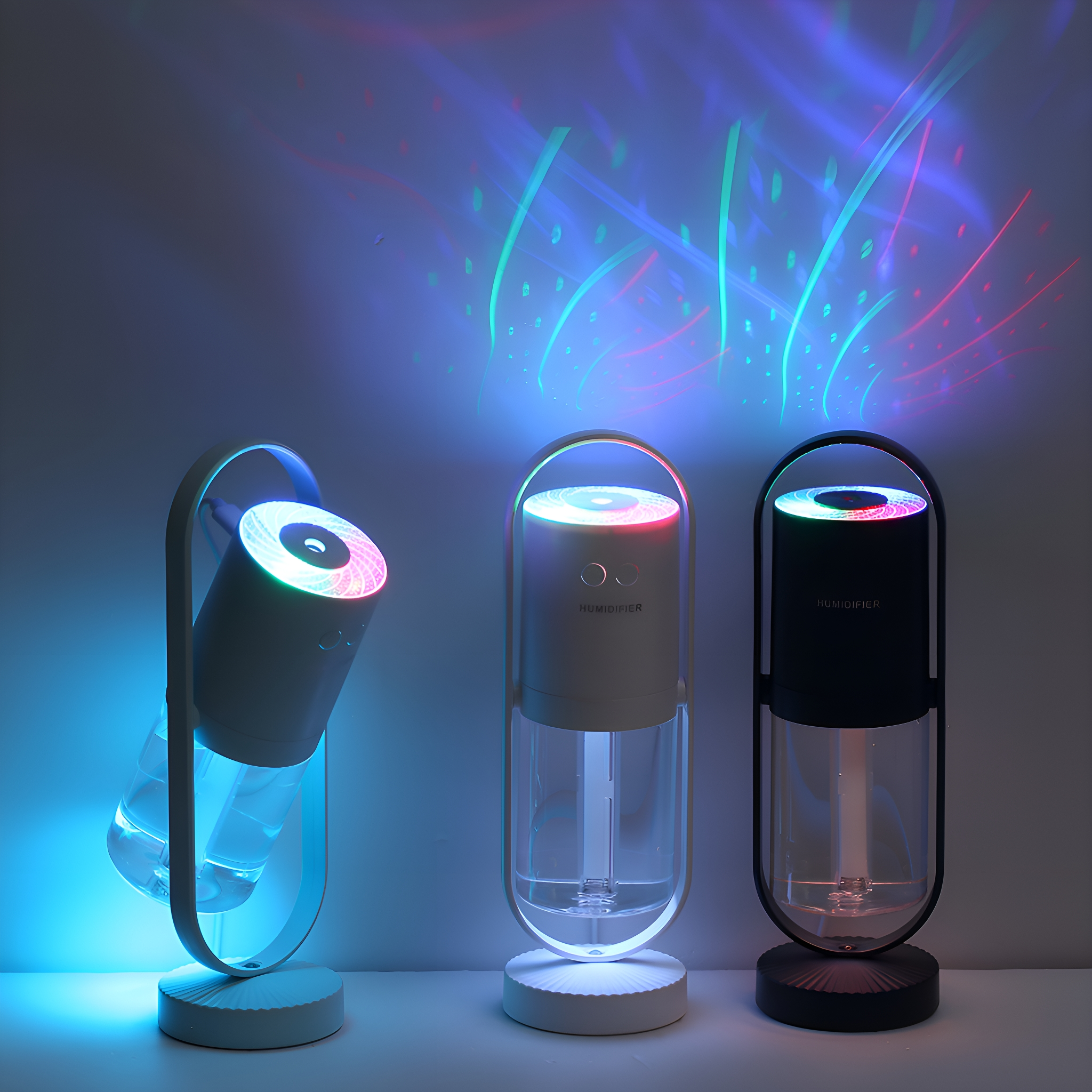 Drei Luftbefeuchter, bunte Lichter. Einer geneigt. Weiß, schwarz und transparent. Lichter projizieren nach oben.