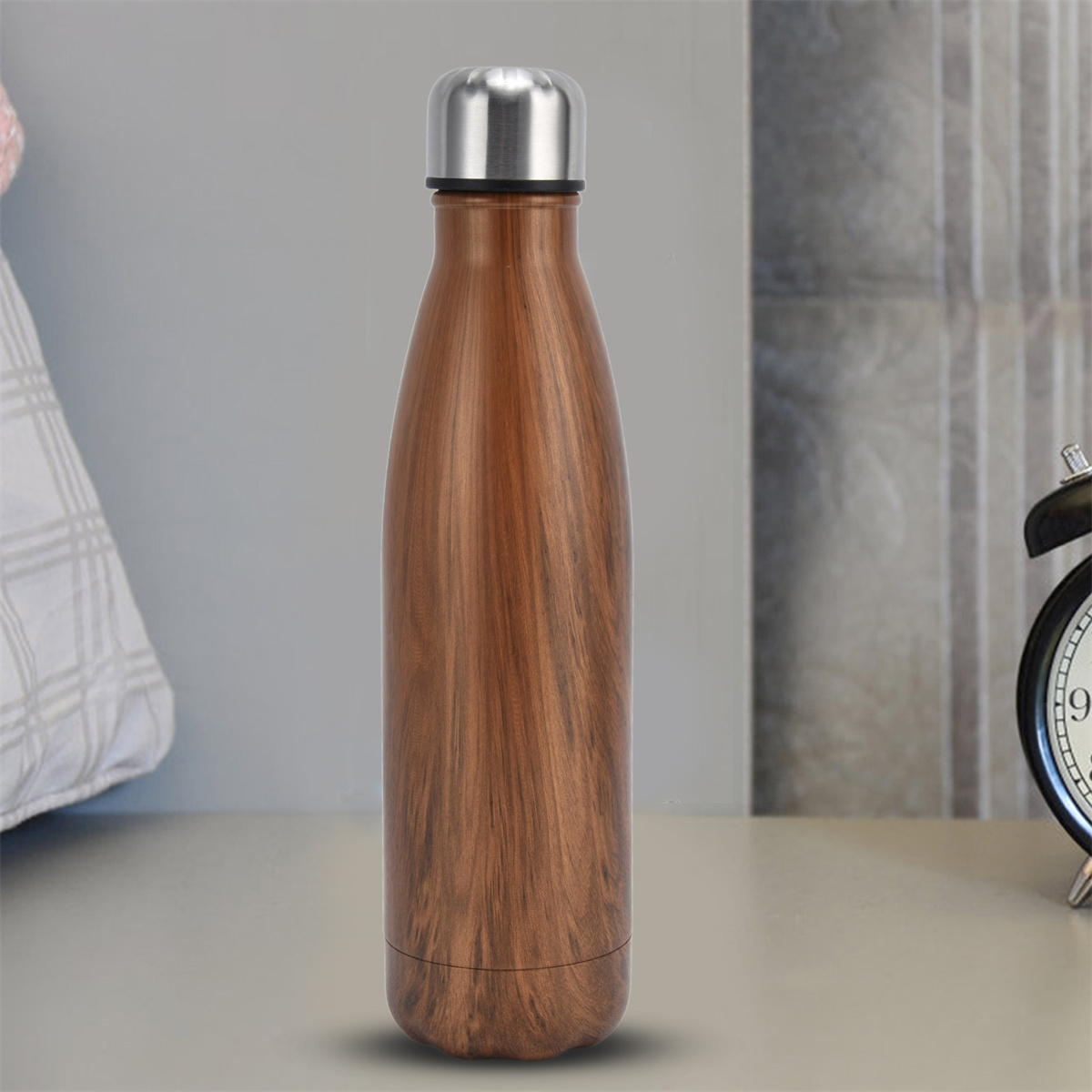 Wasserflasche aus Edelstahl mit Holzmaserung auf einem Tisch.