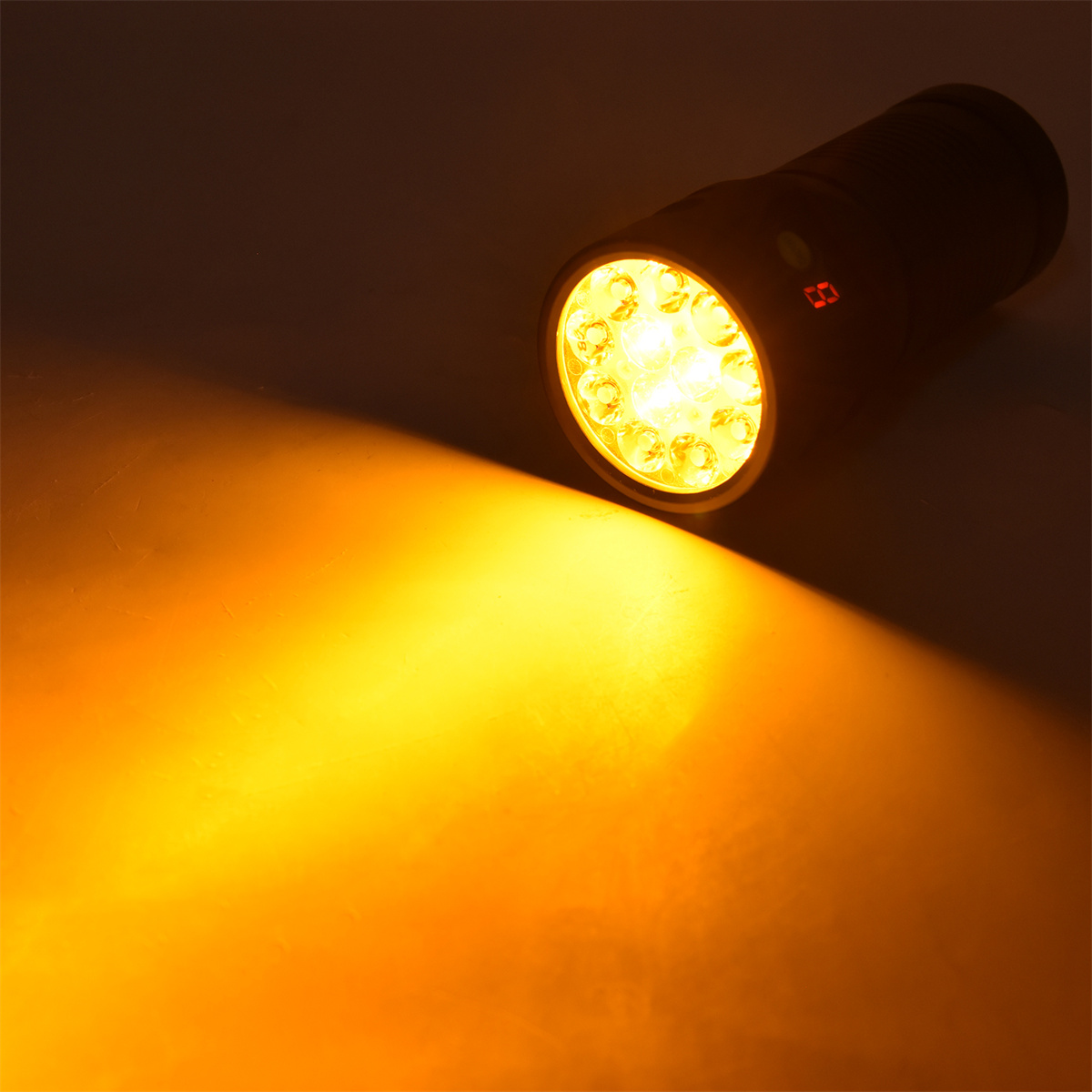 Eine schwarze Taschenlampe, die ein hellgelbes Licht auf eine Oberfläche scheint.