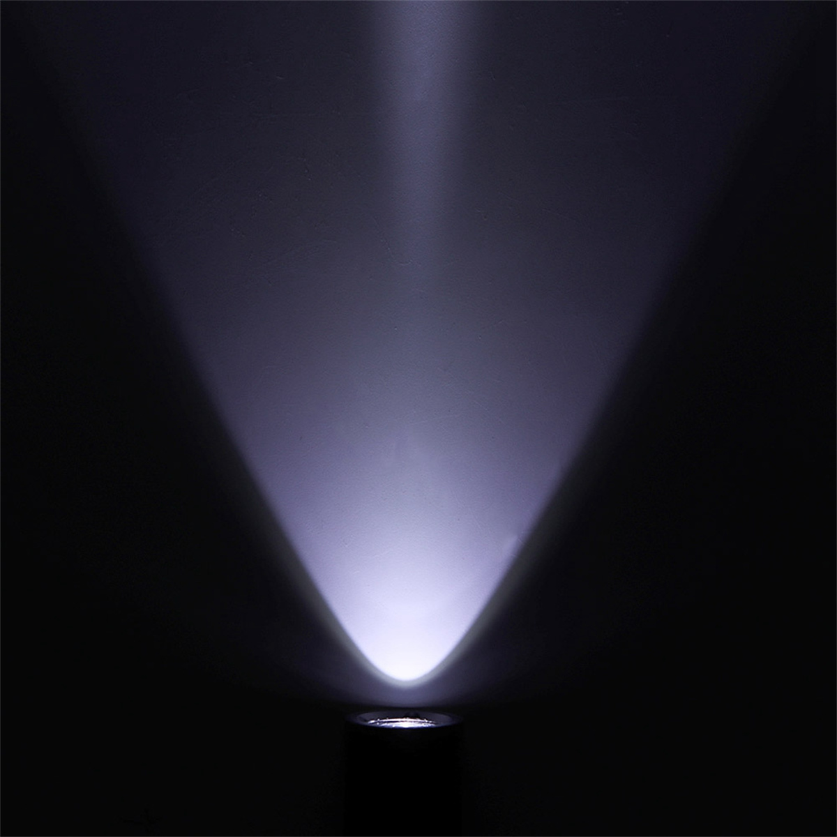 Dunkler Raum, beleuchtet von einem einzigen Scheinwerfer, der einen hellen Lichtstrahl erzeugt.