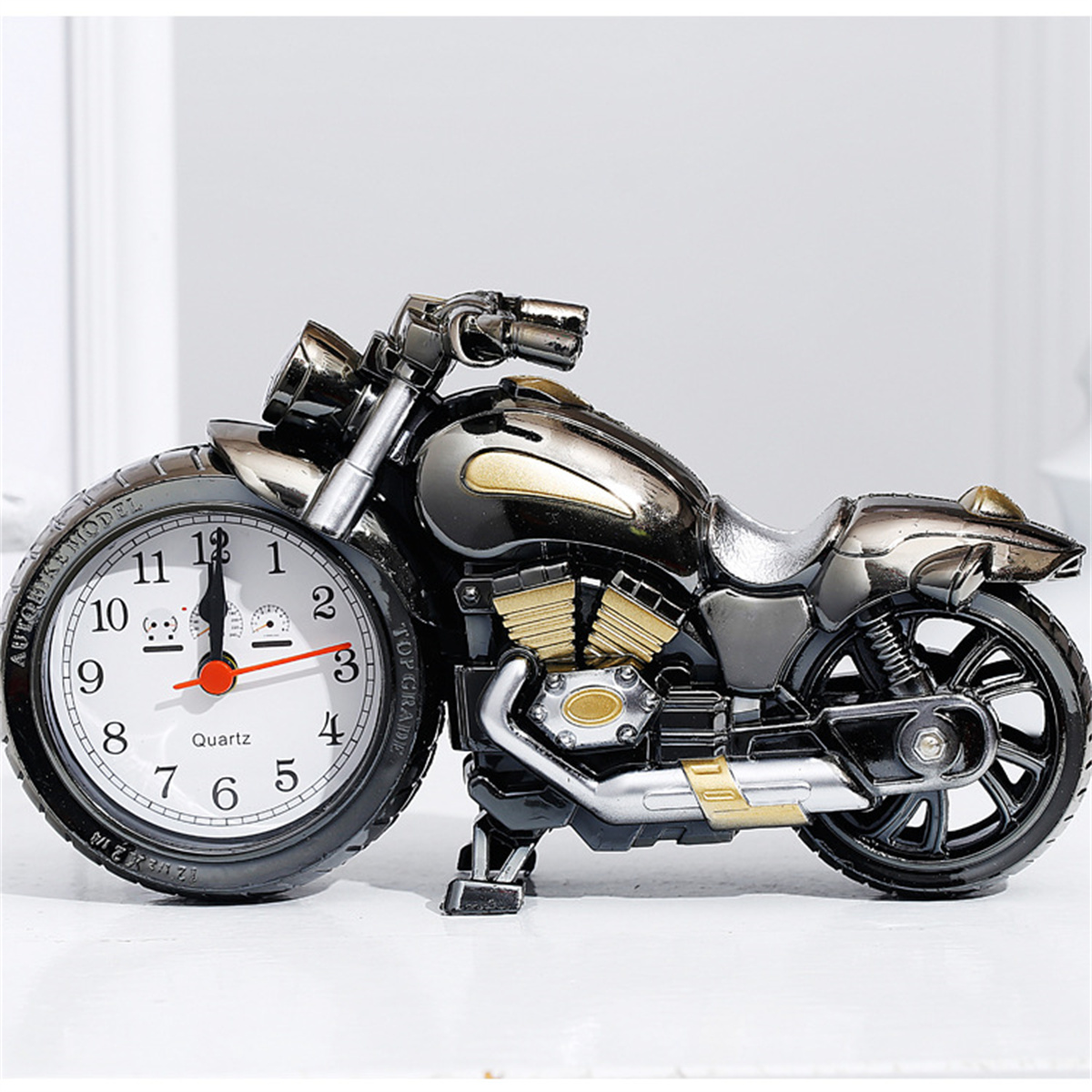 Eine Motorrad-förmige Uhr auf einer weißen Oberfläche.