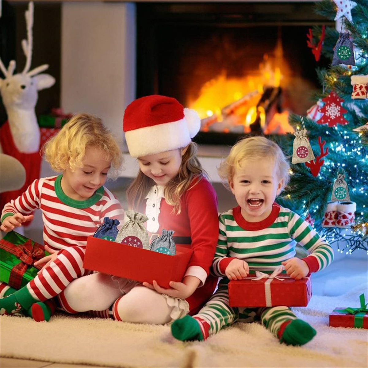 Kinder am Weihnachtsbaum. Drei Kinder mit Geschenken. Kamin im Hintergrund.